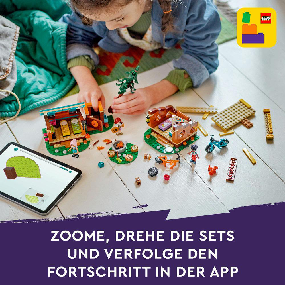 Ein Mädchen mit einem Lego-Set, einschließlich Tablet mit Anweisungen und verschiedenen Lego-Teilen.