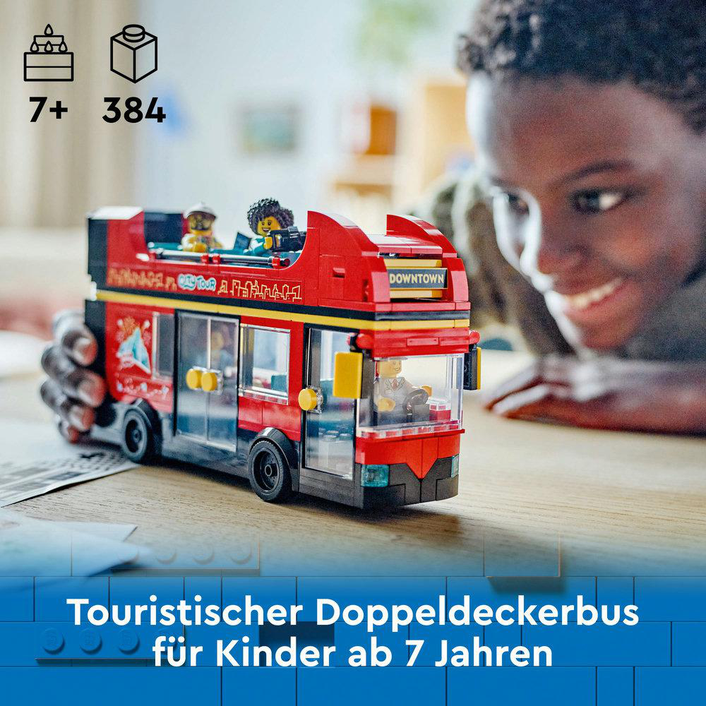 Ein roter und gelber Lego-Bus mit zwei Figuren. Im Hintergrund lächelt ein Junge.