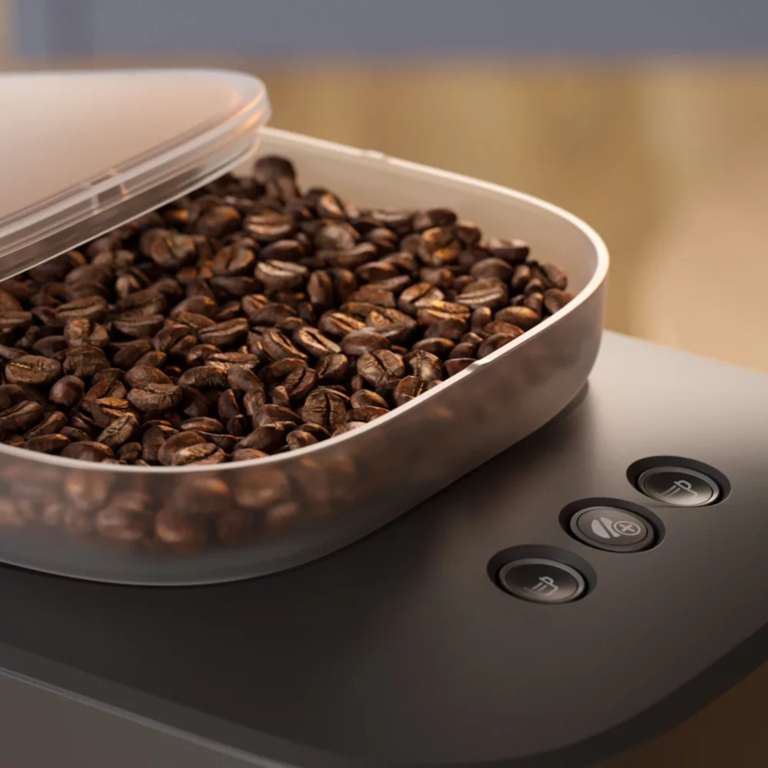 Close-up of coffee beans in a container, with control buttons on a black machine.