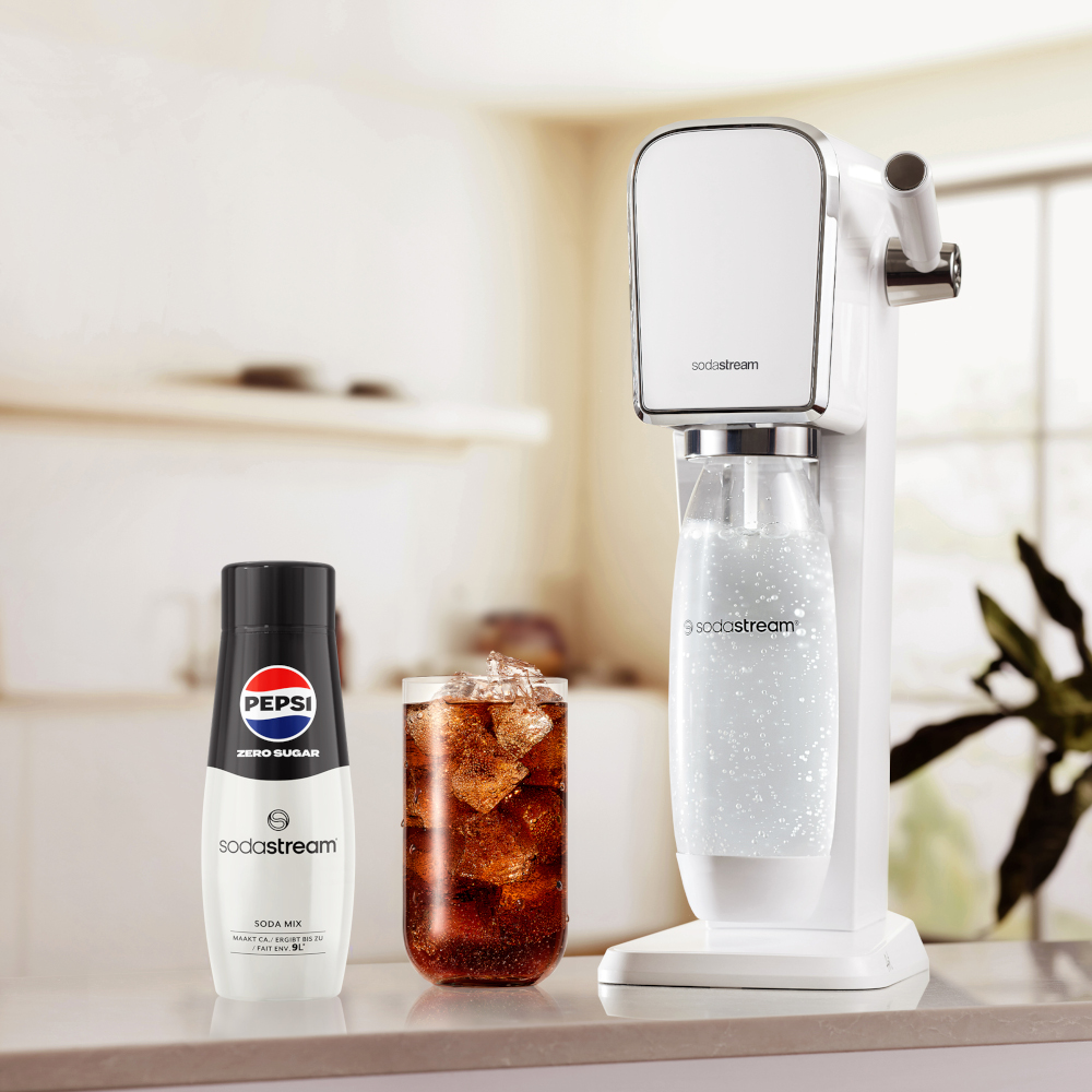 SodaStream machine with a Pepsi Zero Sugar bottle and a glass with cola and ice.