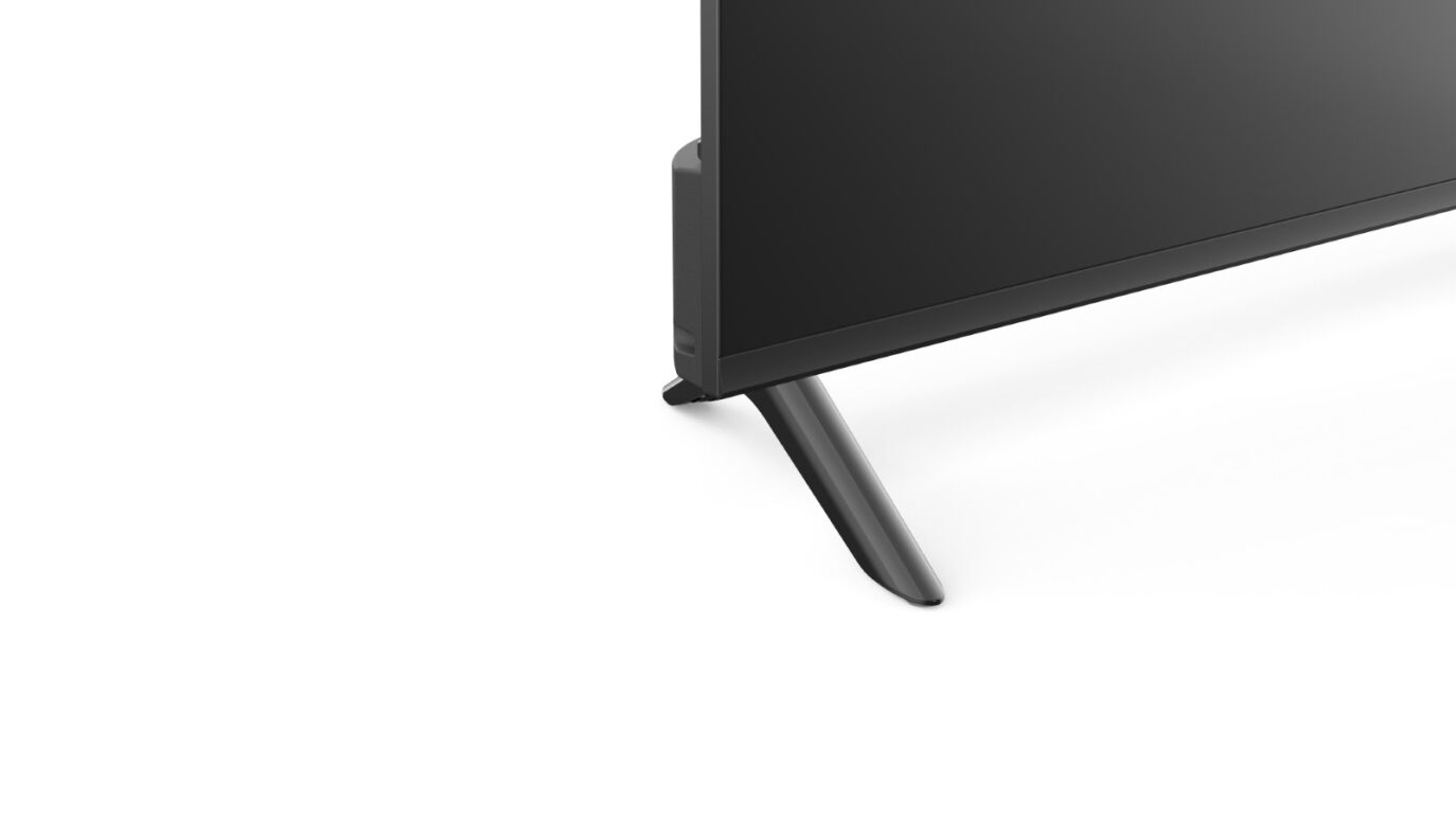 La esquina inferior derecha de un televisor negro. El televisor tiene un soporte negro, fondo blanco.