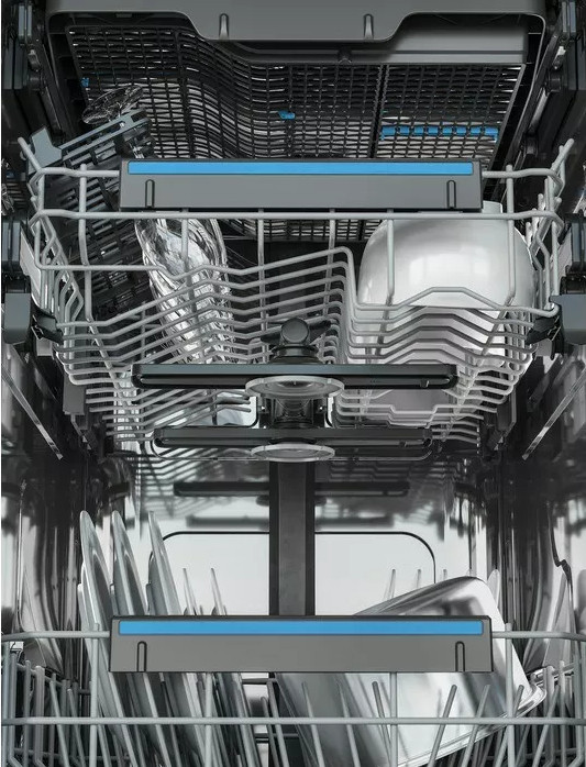 Wnętrze zmywarki z półkami, pokazujące różne czyste naczynia i przybory.