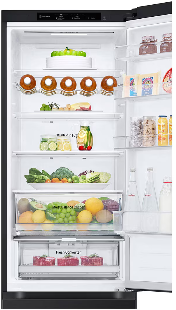 Un réfrigérateur ouvert rempli de nourriture, y compris des fruits, des légumes et des contenants. L'intérieur est bien éclairé.