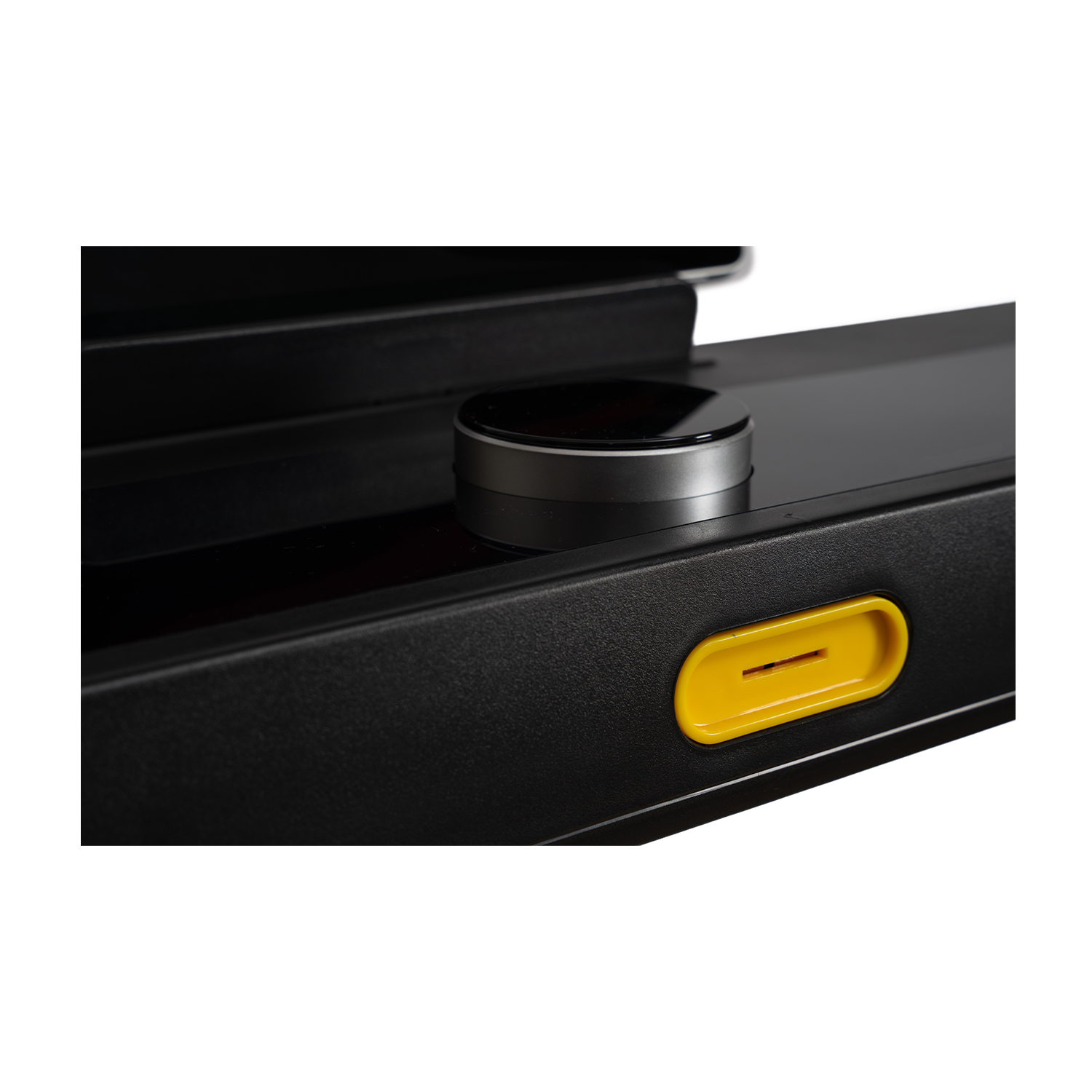 Primo piano di un dispositivo nero con quadrante argentato e slot giallo.