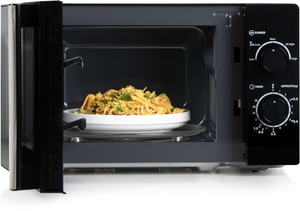 Un four à micro-ondes noir avec des aliments cuits sur une assiette à l'intérieur, ouvert dans une cuisine.