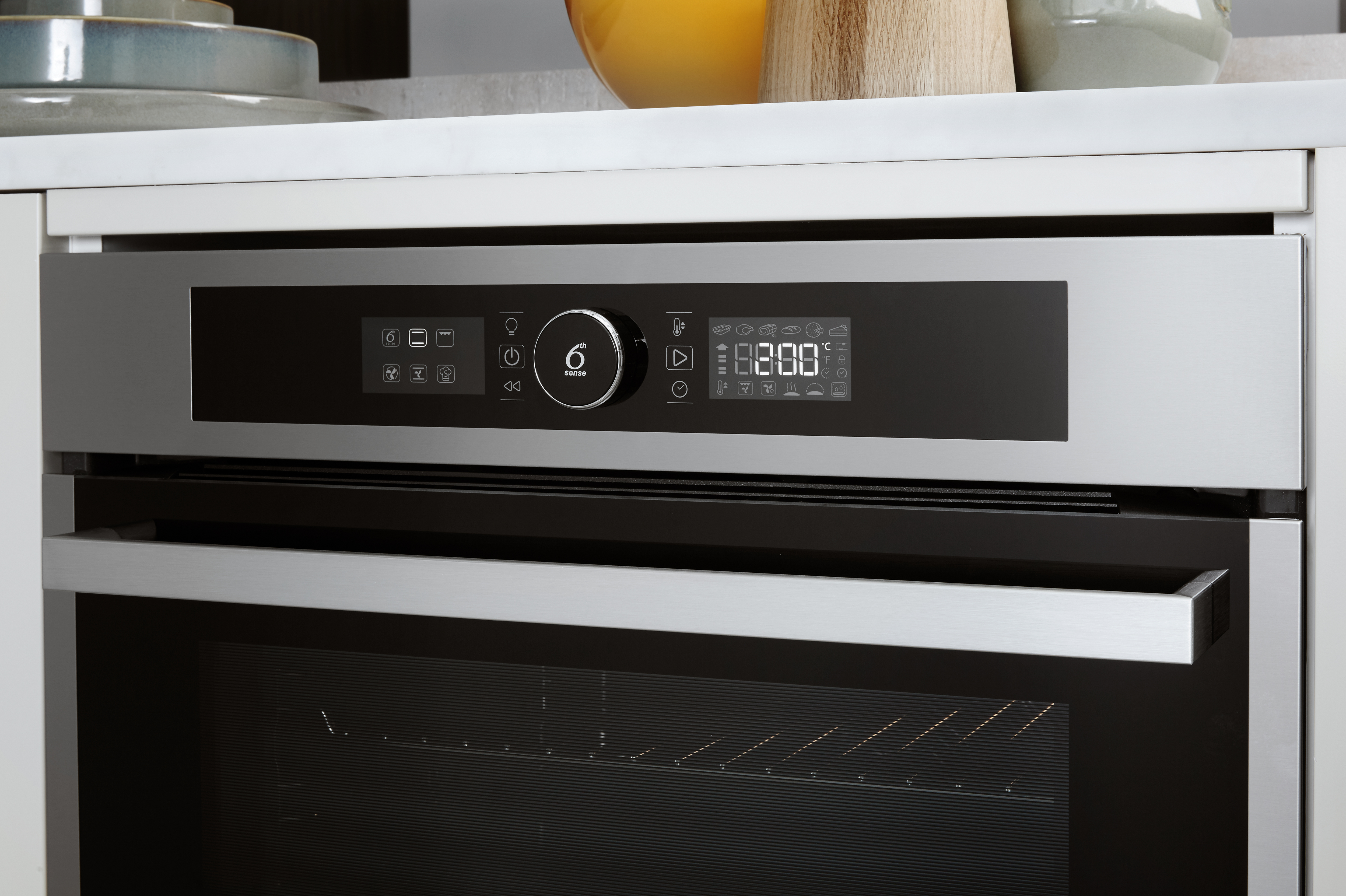 Primer plano del panel de control de un horno. Tiene una pantalla digital que muestra ajustes e iconos.
