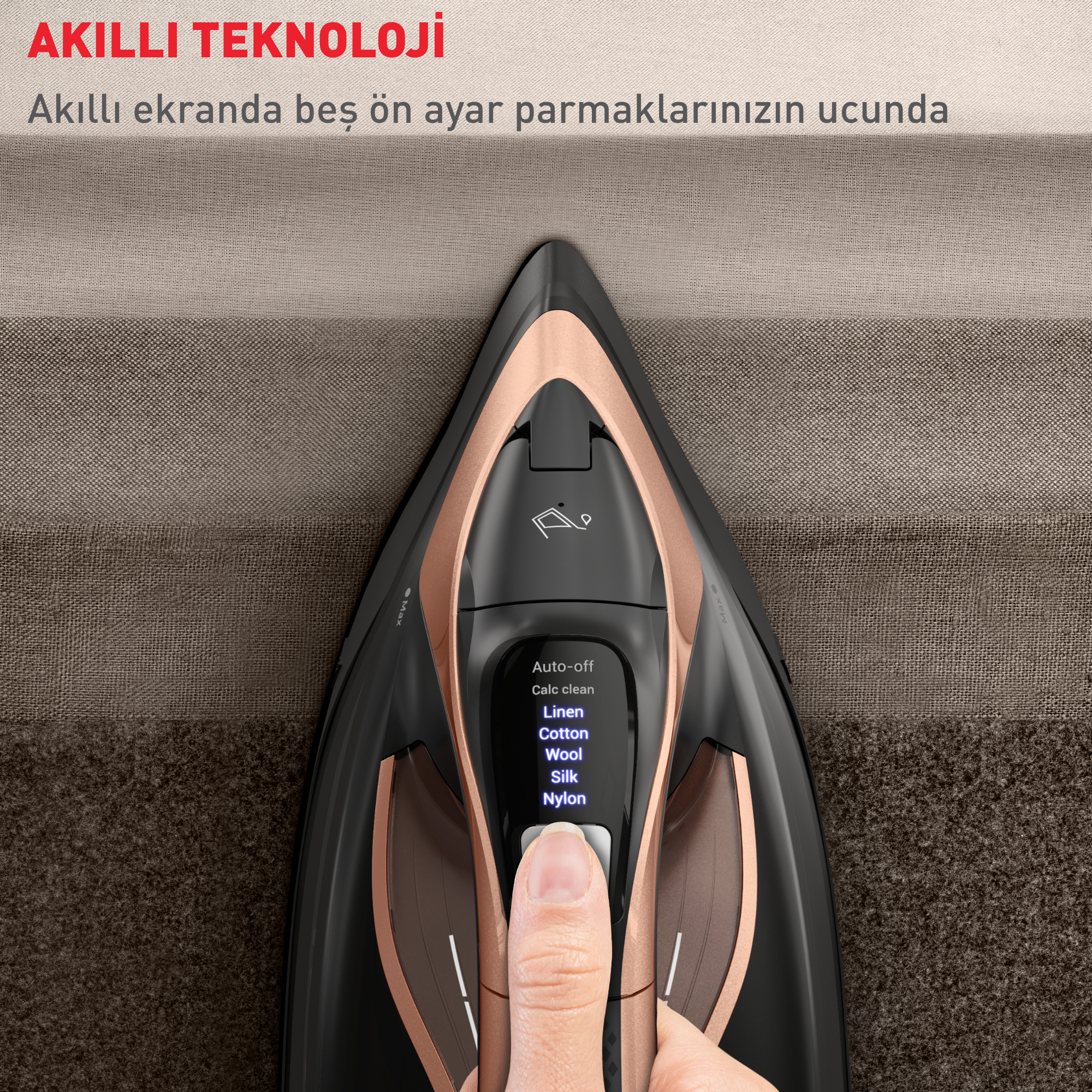 Siyah ve gül altın rengi bir ütü, kontrol paneli ve kahverengi bir yüzeyde el.