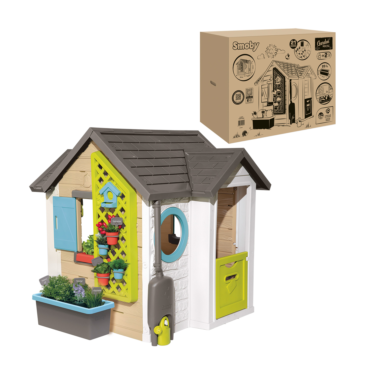 Una casetta per bambini con porta verde, persiane blu e una scatola di cartone sullo sfondo.