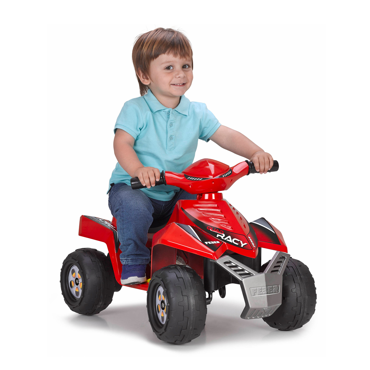 Un ragazzino che guida un quad giocattolo rosso e nero. Sta sorridendo.