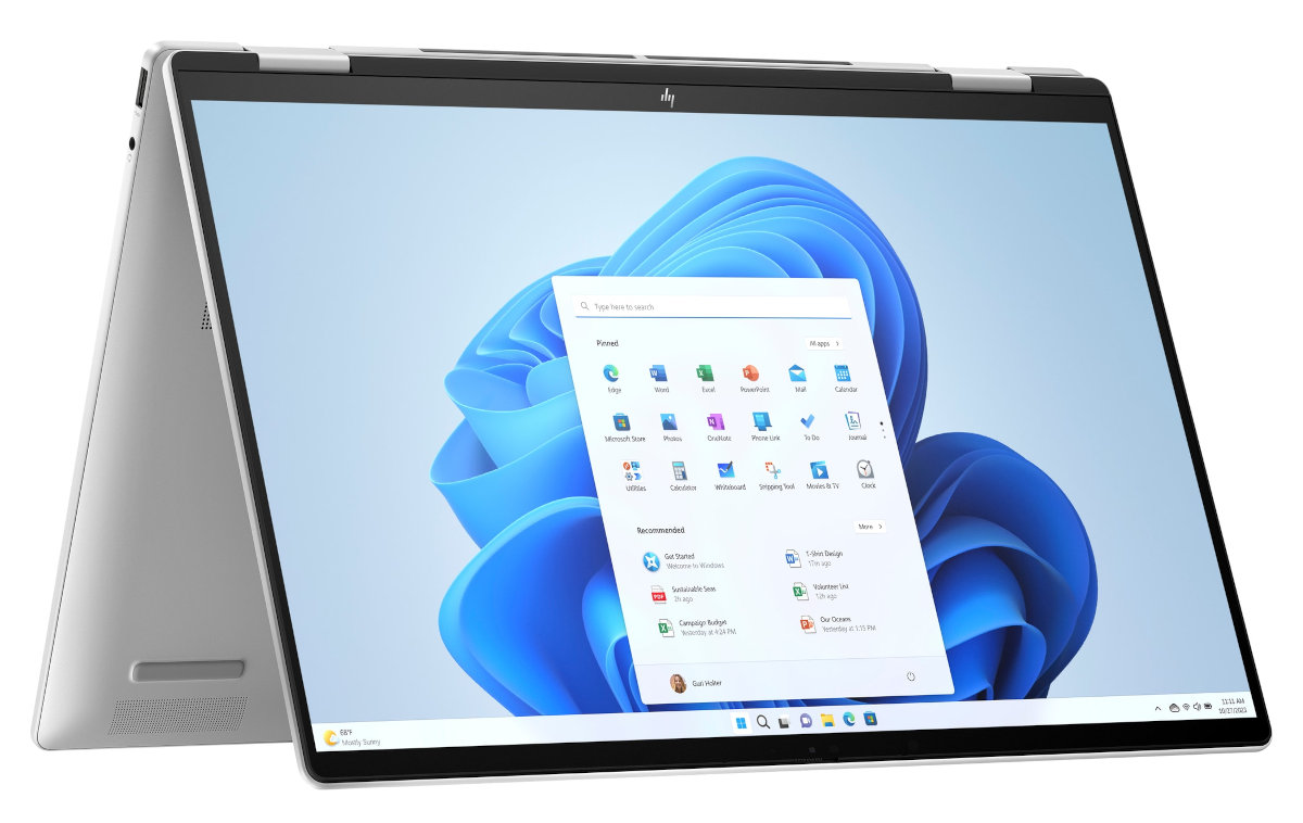 Srebrny laptop HP, otwarty, z Windows 11. Ekran z ikonami aplikacji. Białe tło.