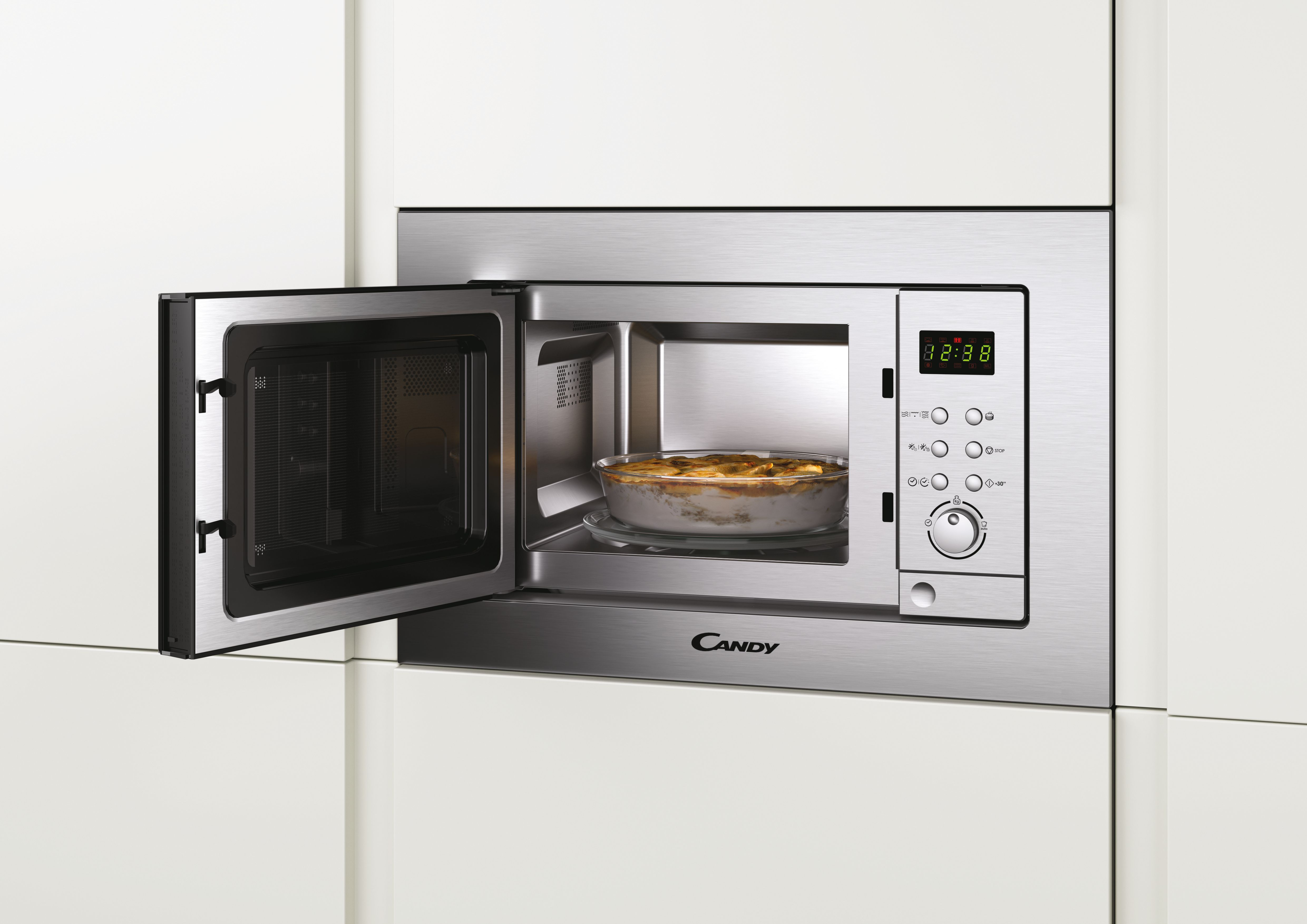 Horno microondas instalado en un armario de cocina, puerta abierta, con comida dentro.