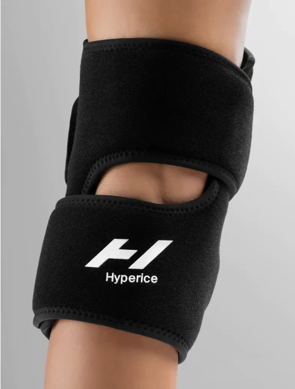 Egy személy karja fekete Hyperice térdrögzítővel.