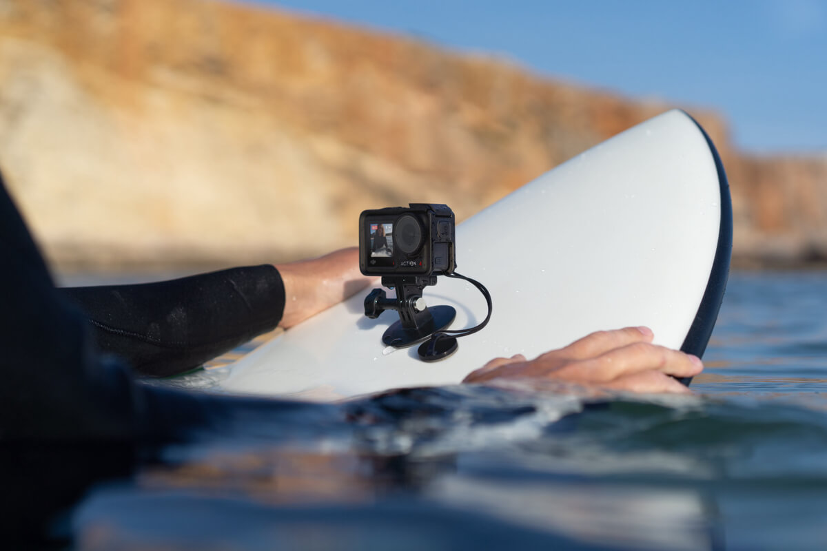 Eine Person auf einem Surfbrett mit einer Action-Kamera im Ozean.