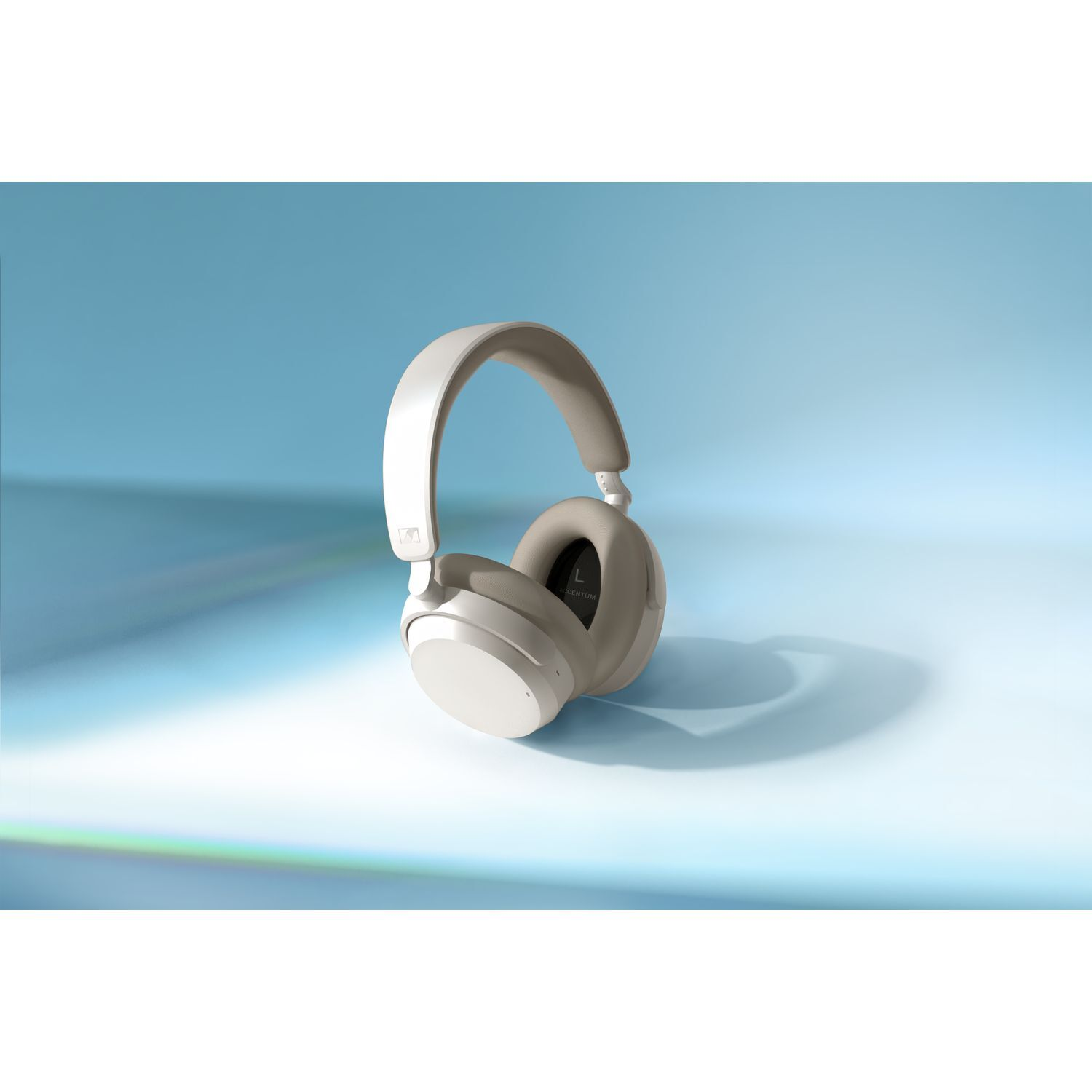 Off-white headphones on a light blue background. The headphones are wireless and over-ear.