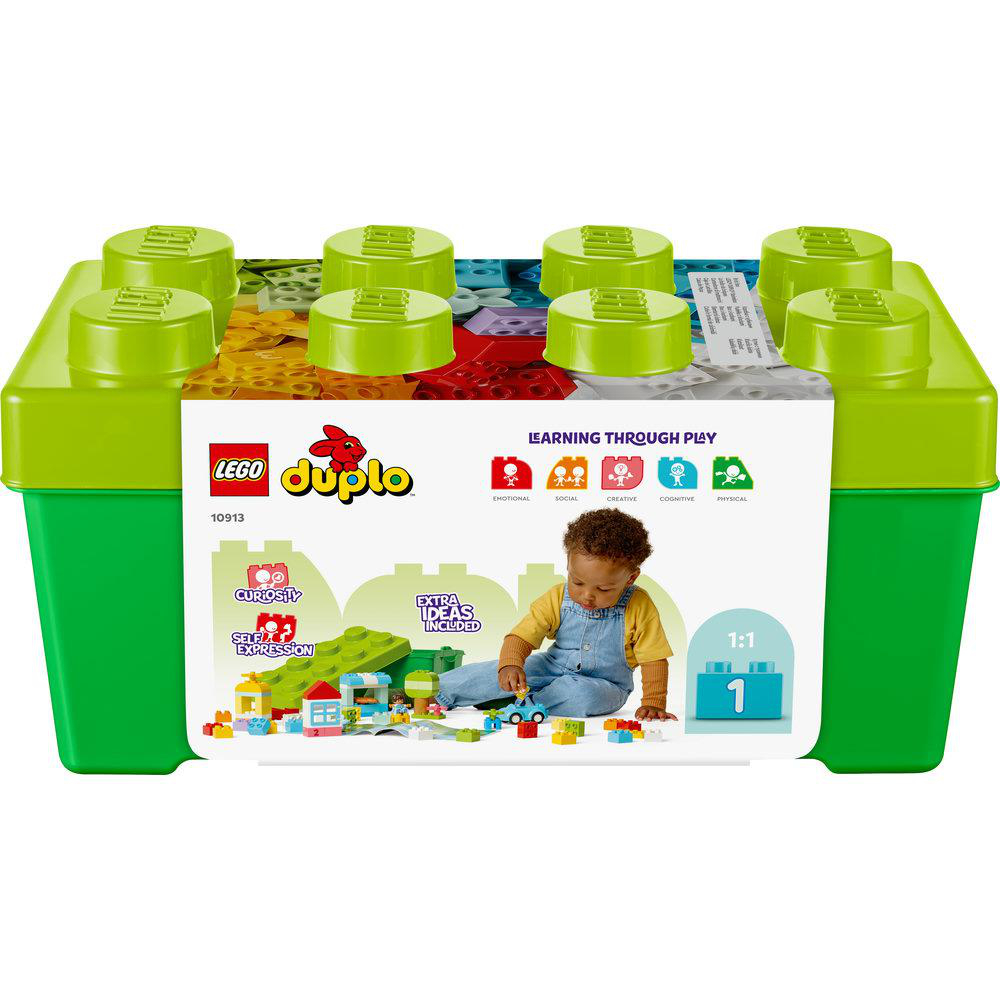 Ein Kind spielt mit bunten Lego Duplo Bausteinen in einer grünen Kiste.