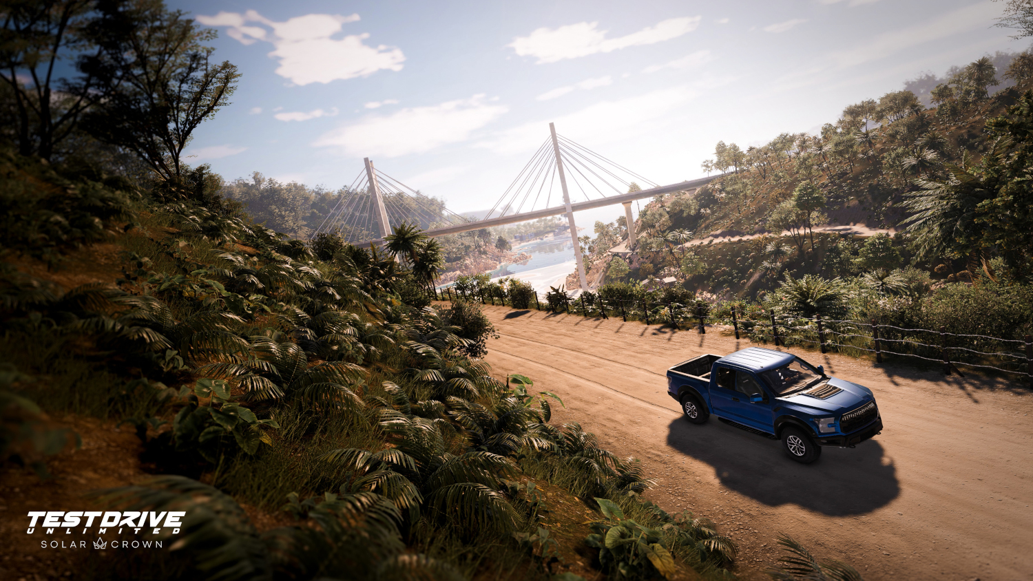 Un camion bleu roule sur un chemin de terre vers un pont dans un environnement verdoyant et luxuriant.