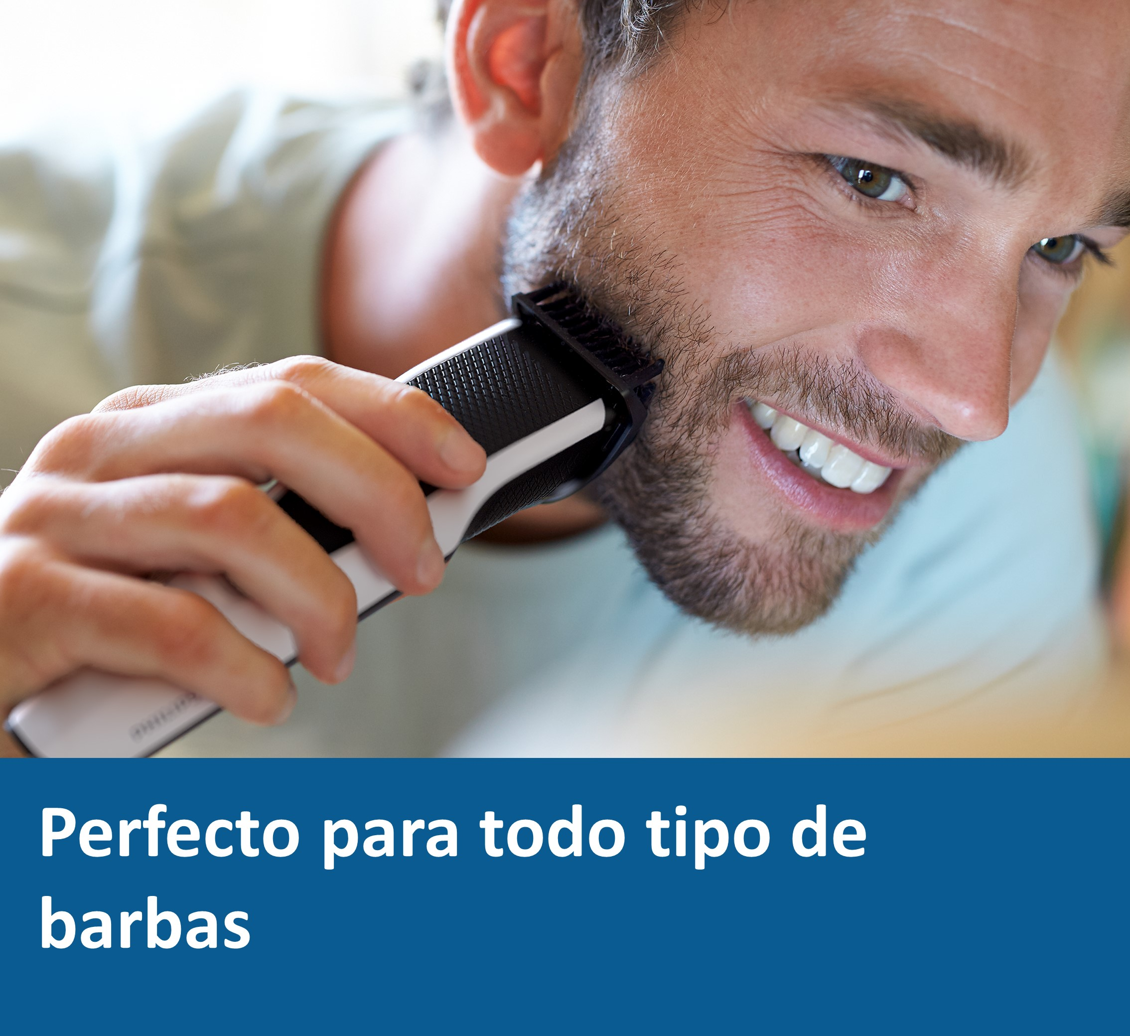 Un hombre se afeita la barba con una recortadora en blanco y negro. Está sonriendo.