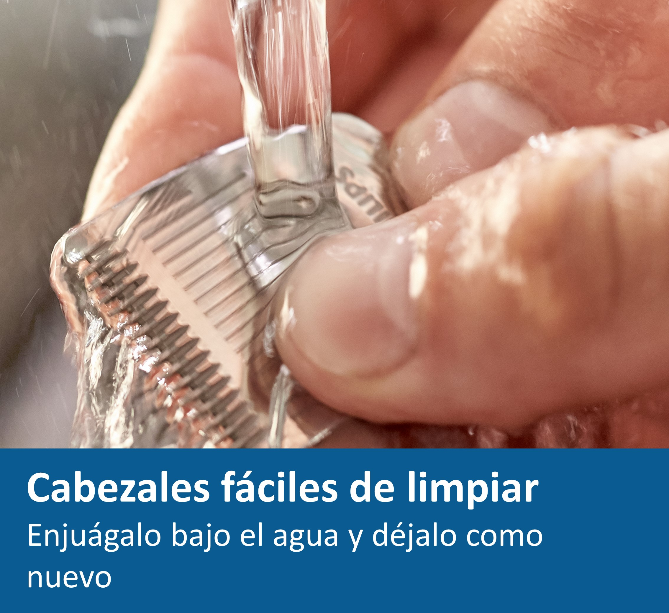 Manos enjuagando un cabezal de afeitadora bajo agua corriente.