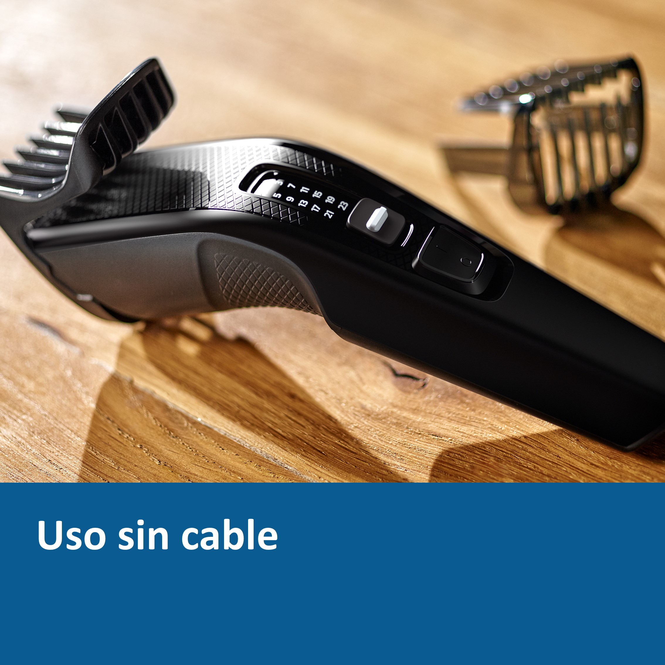 Cortapelos negro con accesorios de peine. Fondo de madera.