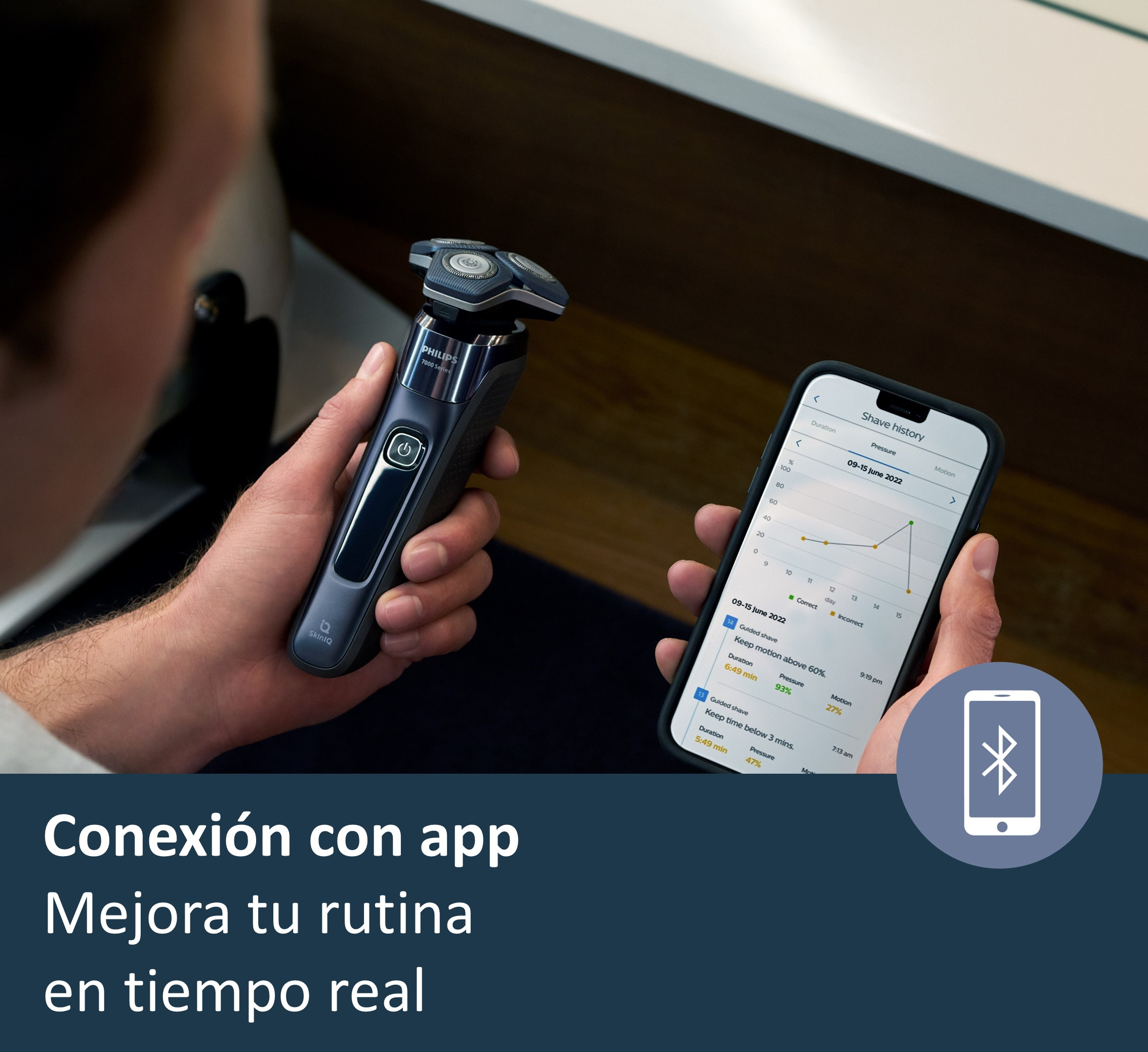 Un hombre sostiene una afeitadora y un teléfono que muestra una aplicación de historial de afeitado.