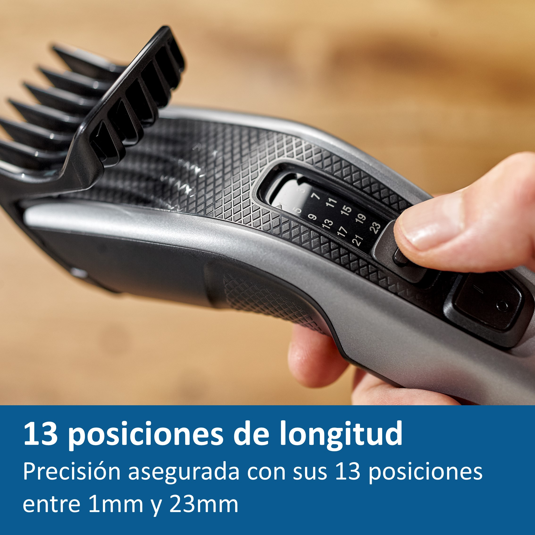 Primer plano de una cortadora de cabello plateada y negra. Persona ajusta la configuración de longitud.