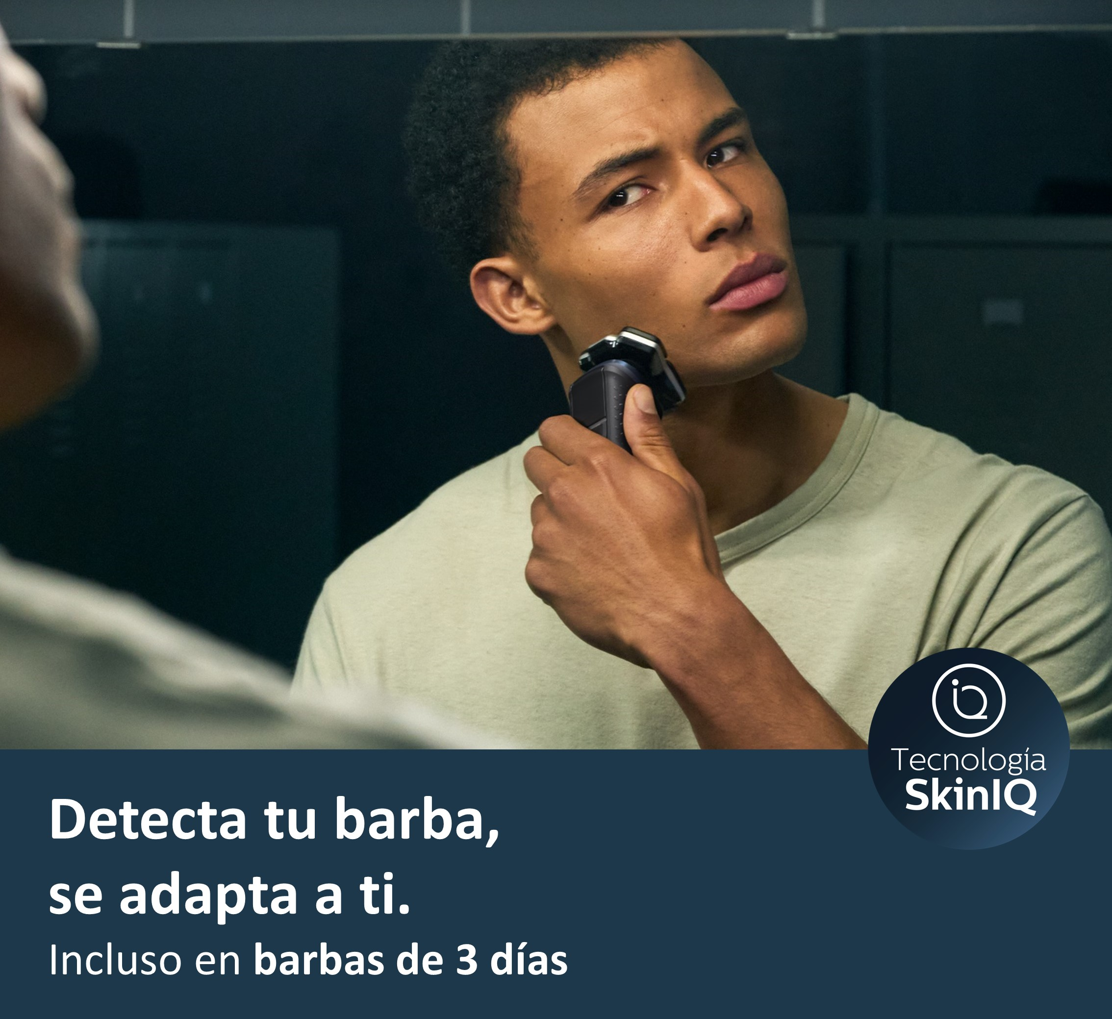 Hombre afeitándose con afeitadora eléctrica en espejo, mostrando tecnología 'SkinIQ'.
