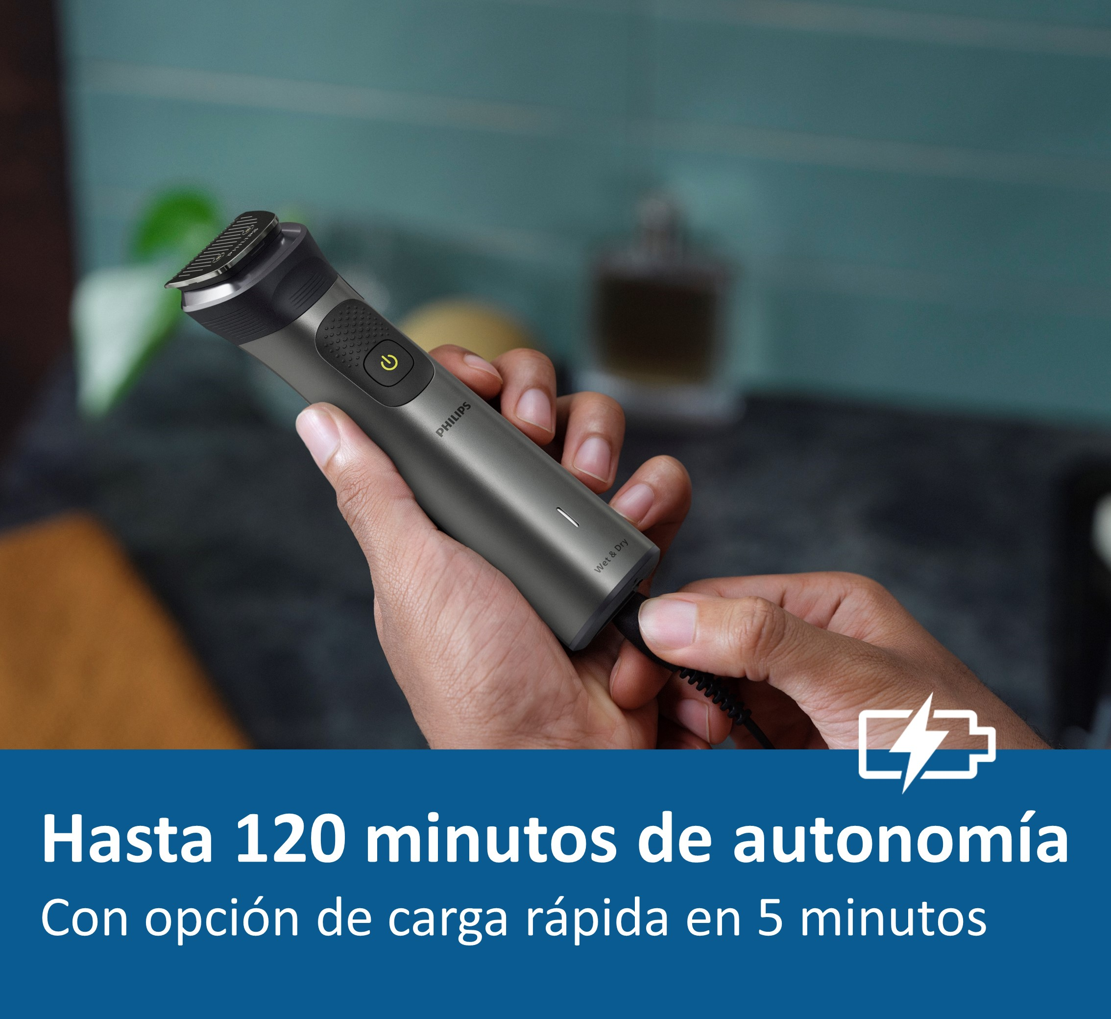 Una mano sosteniendo un recortador gris y negro, con el botón de encendido encendido.