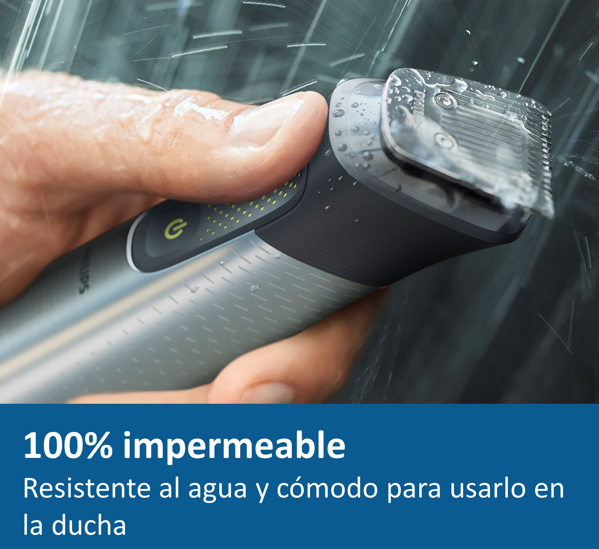 Mano sosteniendo una afeitadora bajo agua corriente. Es plateada y negra, con gotas de agua.