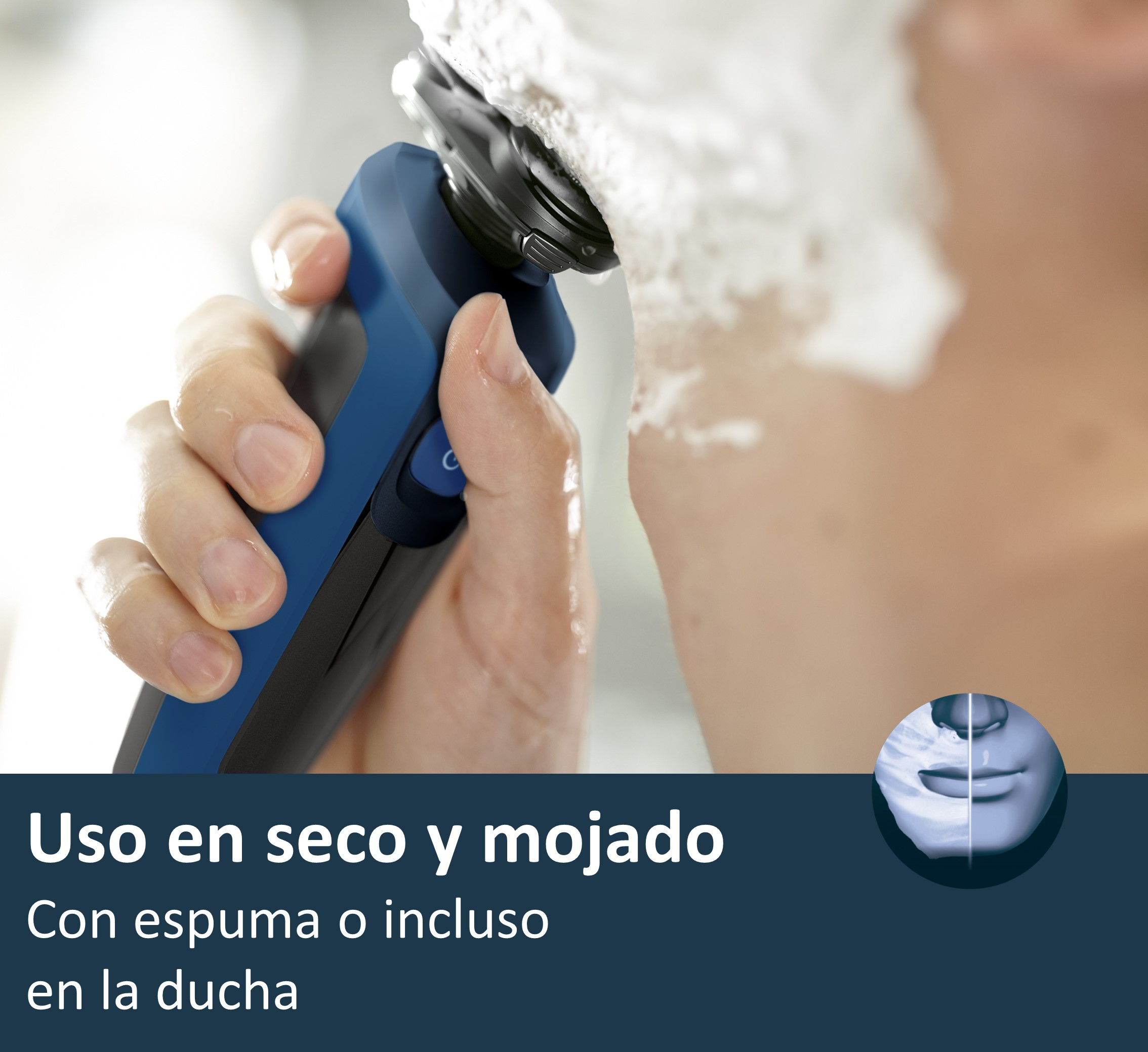 Un hombre se afeita la cara con una afeitadora eléctrica. Se aplica espuma blanca en la cara.