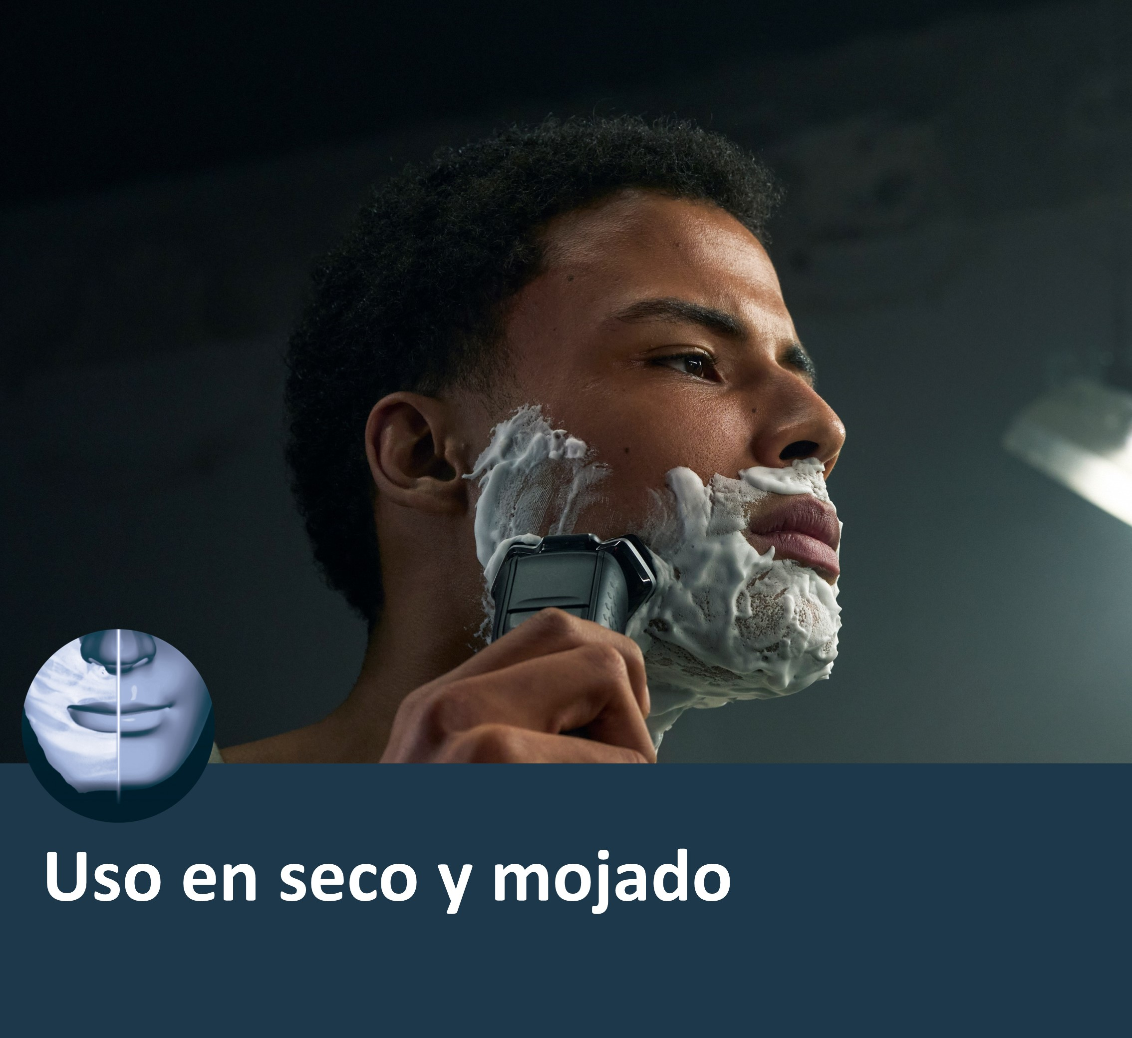 Primer plano de un hombre afeitándose con una afeitadora eléctrica, crema de afeitar visible.