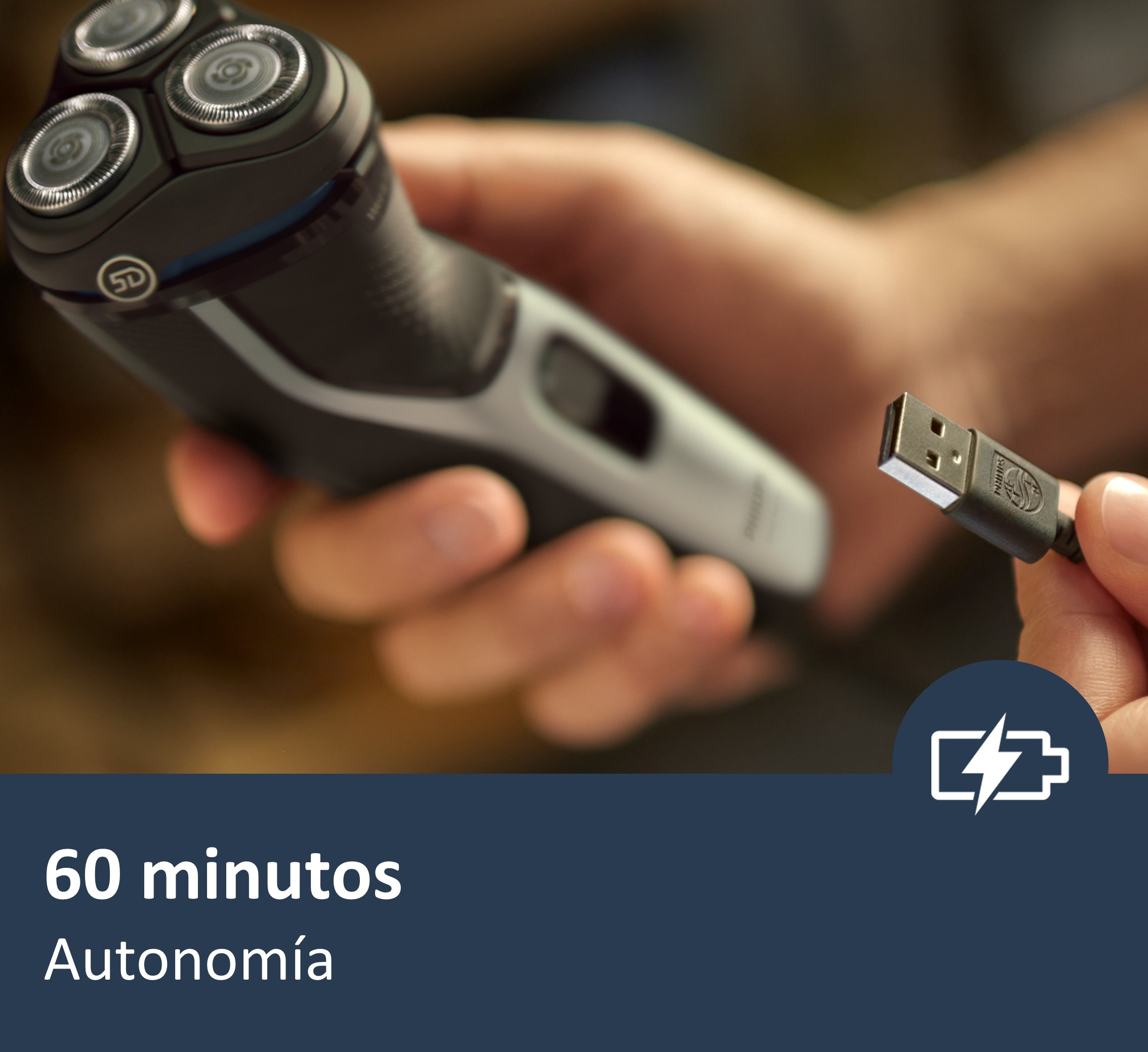 Un hombre sosteniendo una afeitadora. Un cable USB enchufado. Texto: 60 minutos de autonomía.