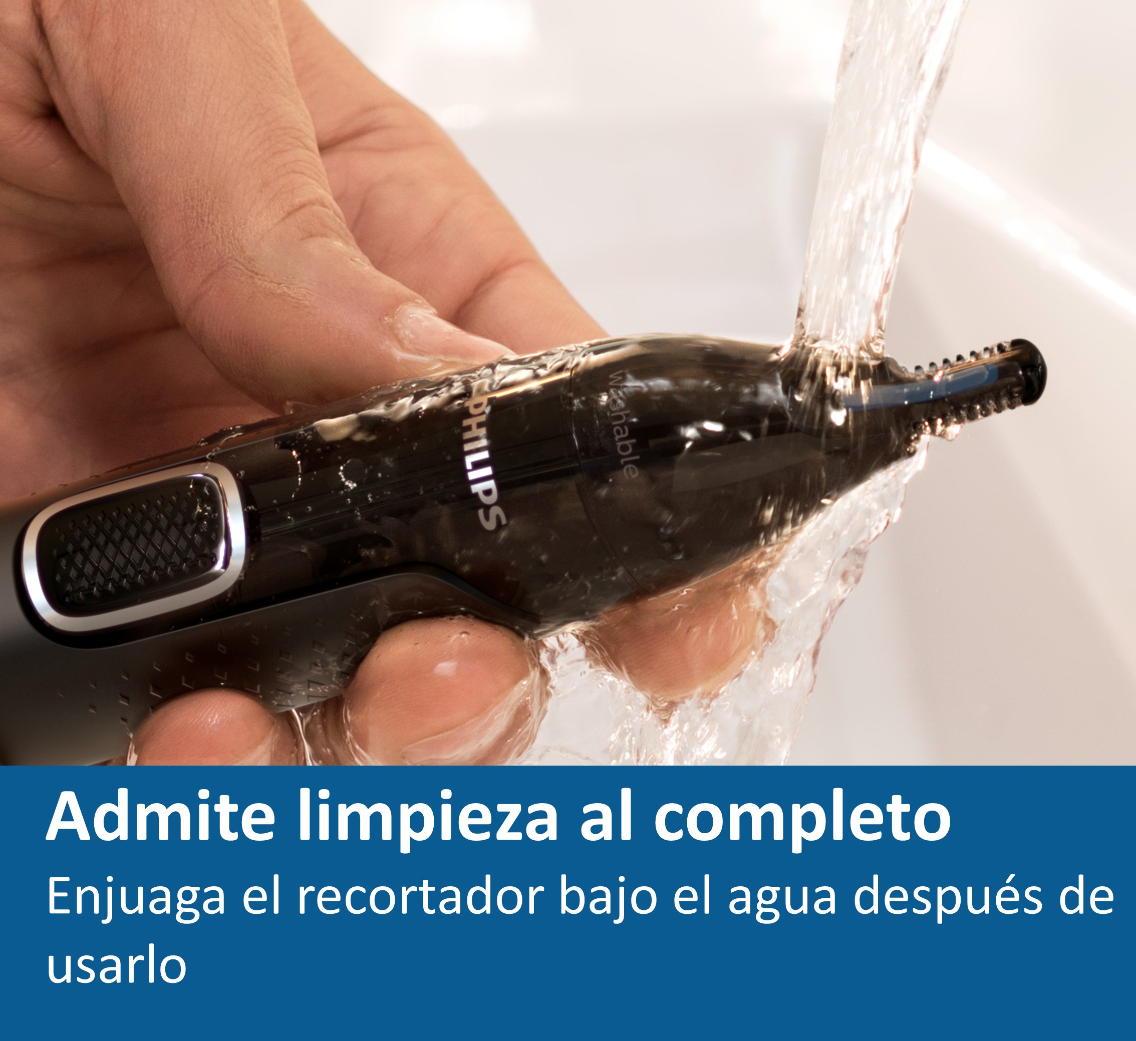 Un recortador negro se limpia bajo agua corriente. Texto: Se permite una limpieza completa.