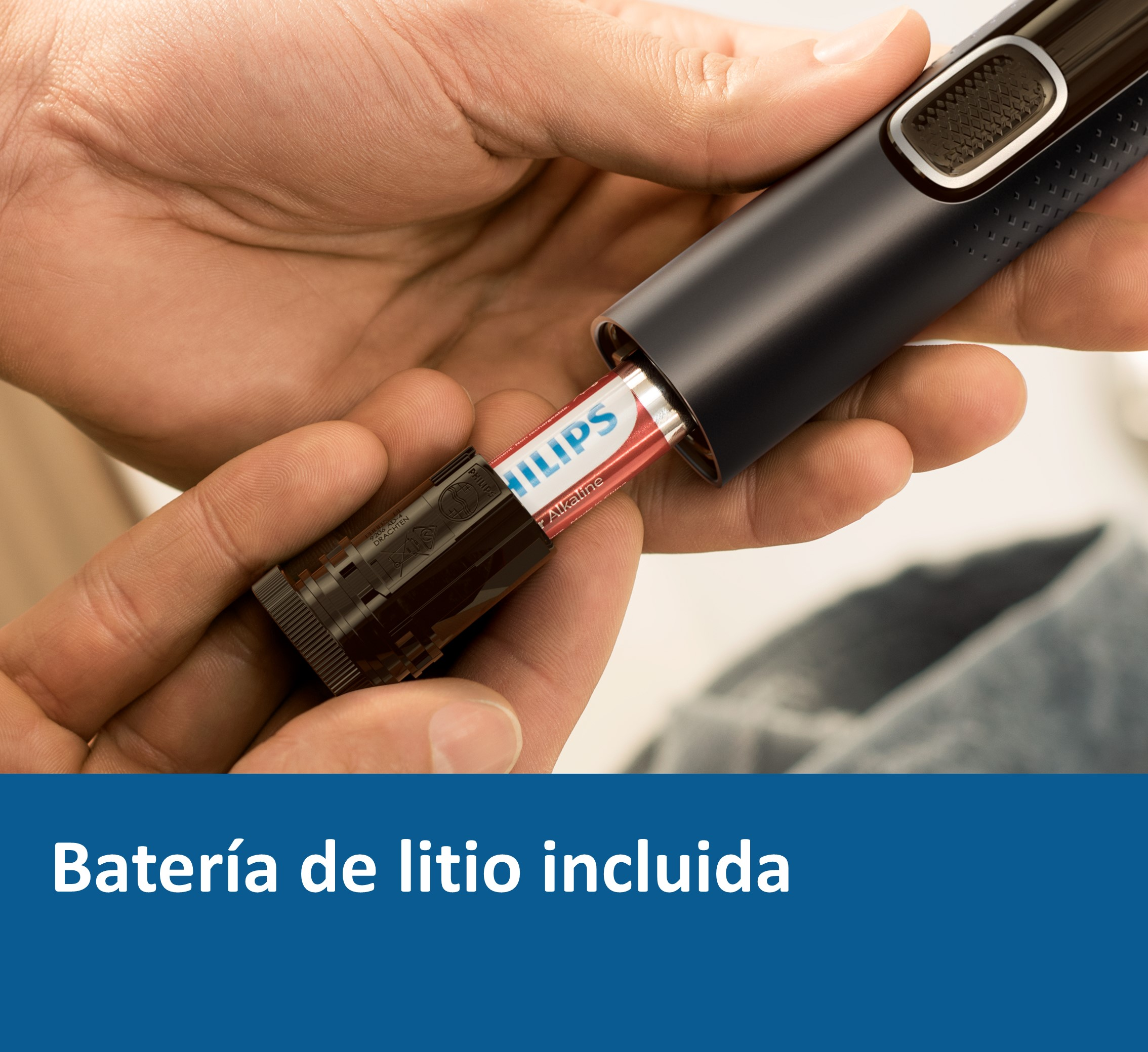 Una mano inserta una pila en una afeitadora negra.