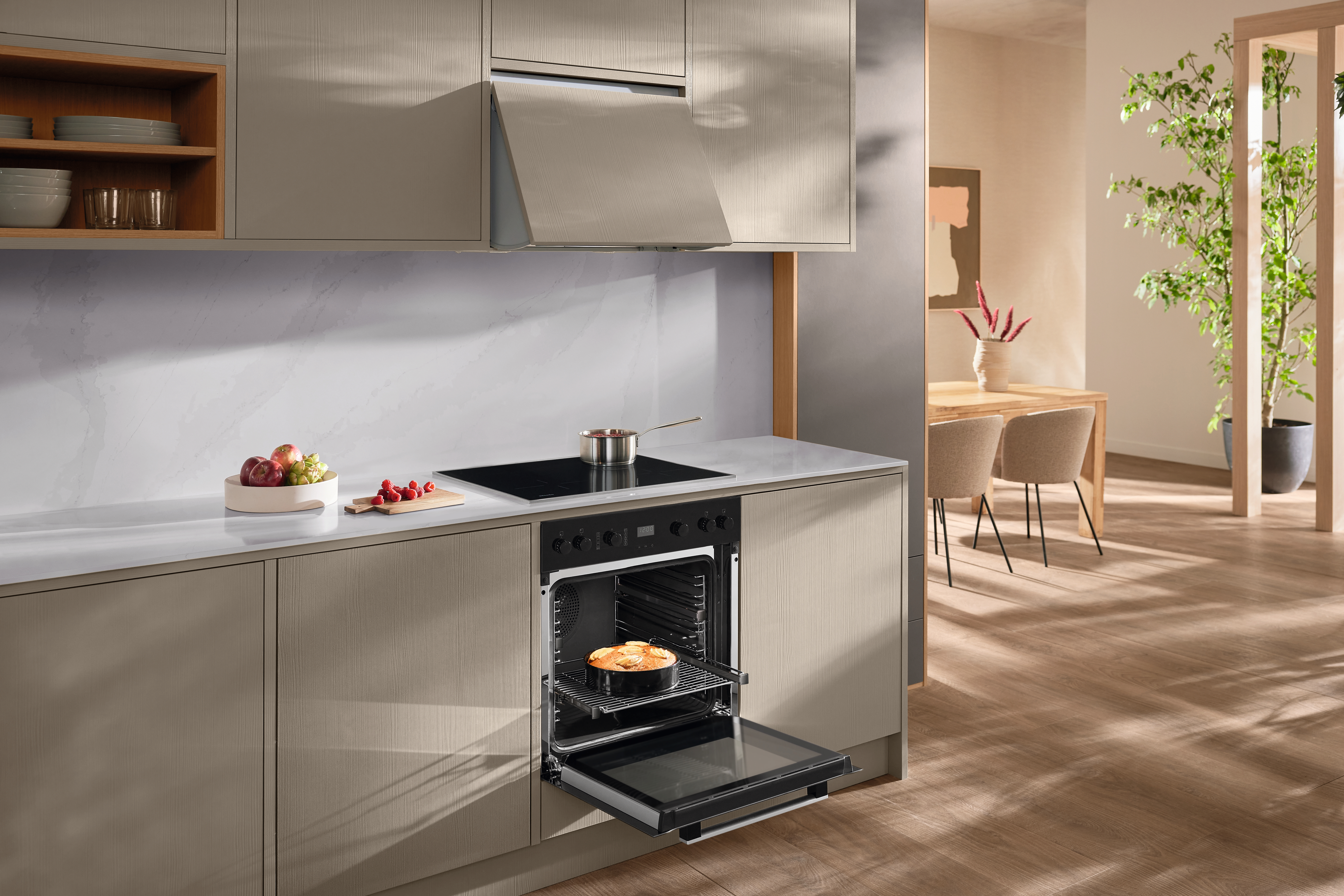 Eine moderne Küche mit Backofen, Arbeitsplatte und einer Person, die einen Kuchen hineingibt.