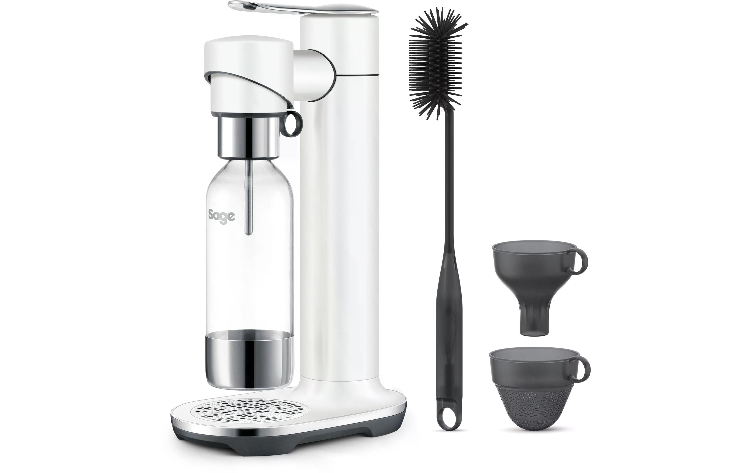 Machine à soda blanche avec accessoires : bouteille, brosse et deux tasses noires.
