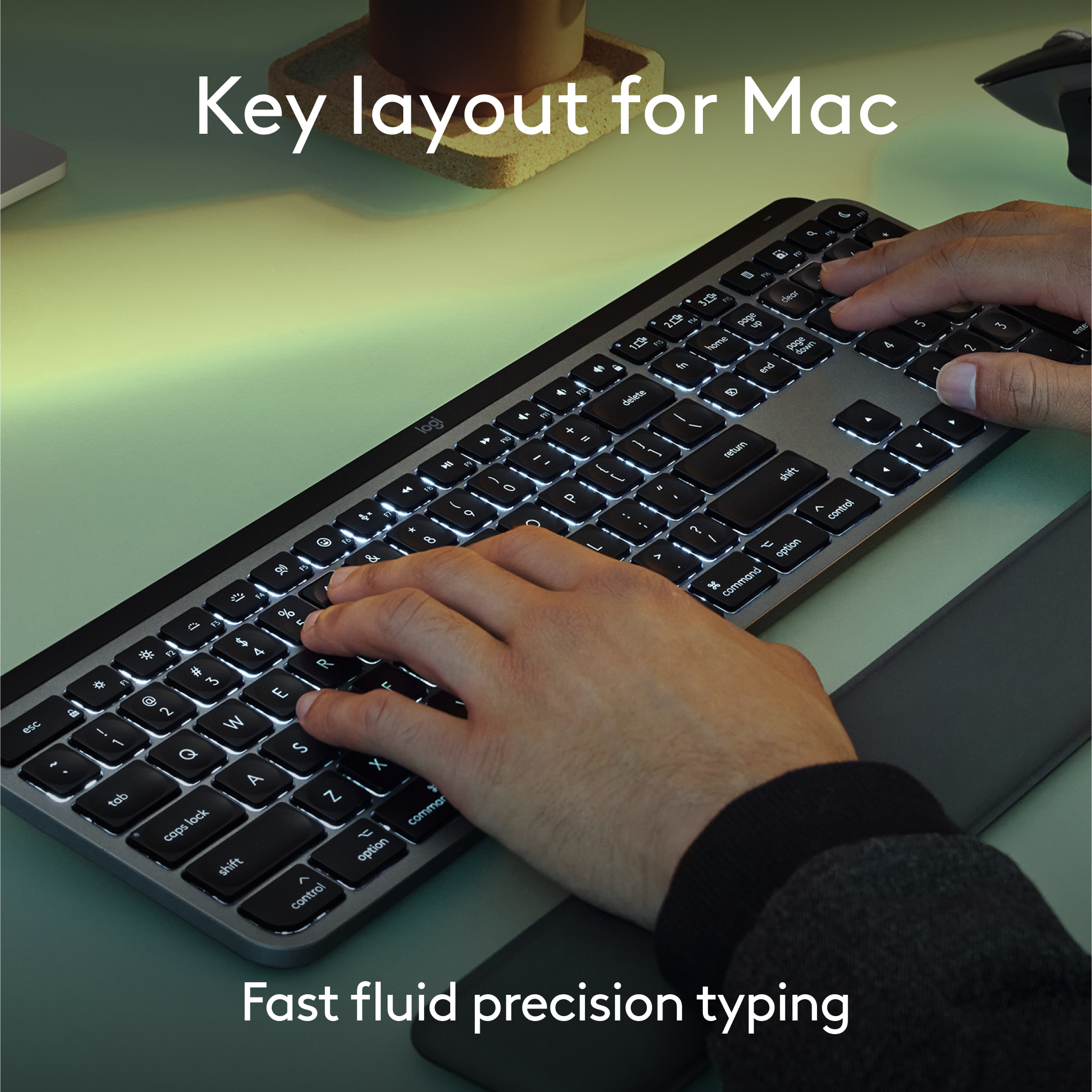 Tastatur für Mac, mit Tipphänden, hellen Tasten, grauer Handgelenkauflage.