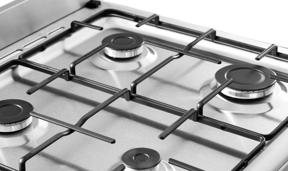 Close-up of a stainless steel stove top with burners and grates.