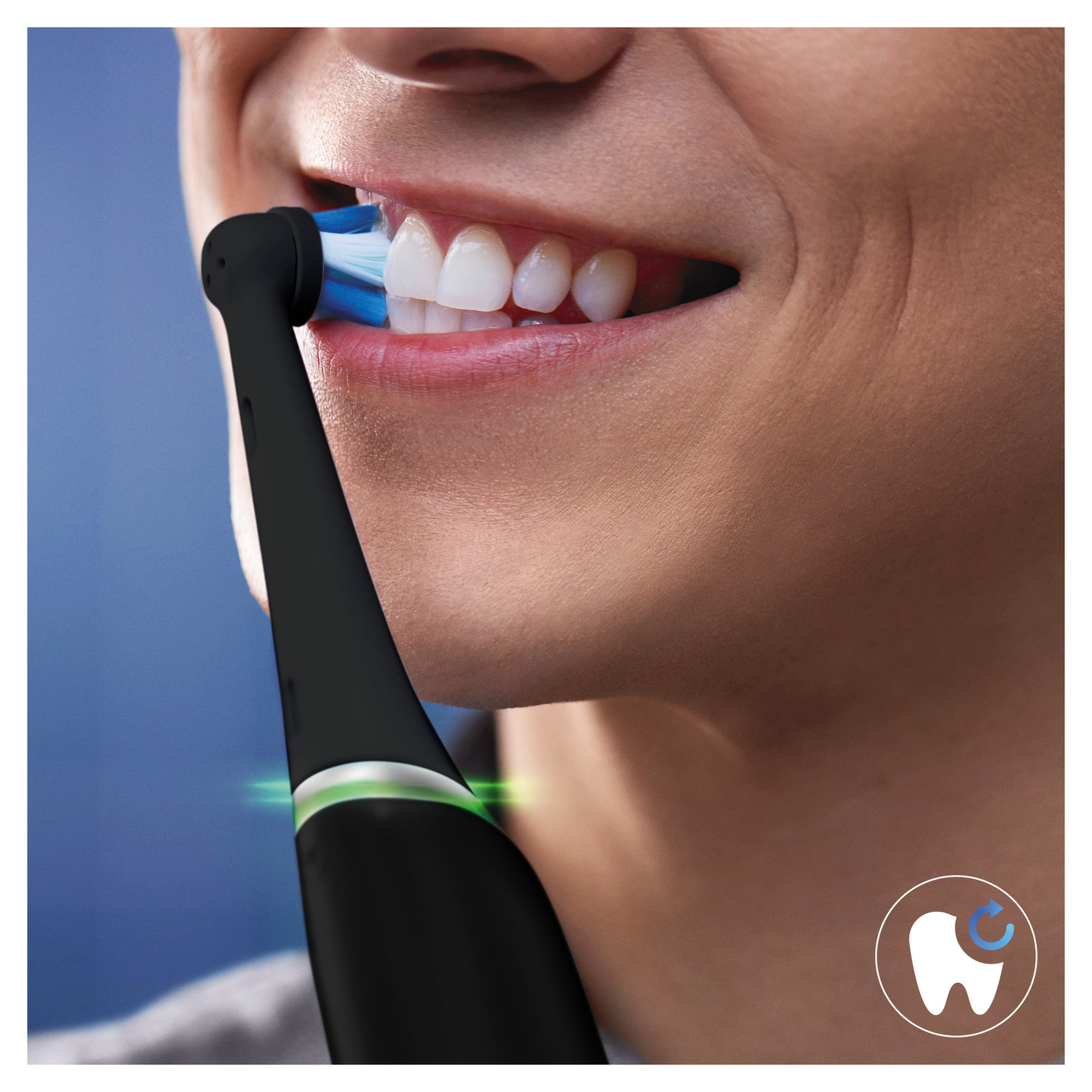 Person brushing teeth with a black electric toothbrush, blue bristles, white teeth.