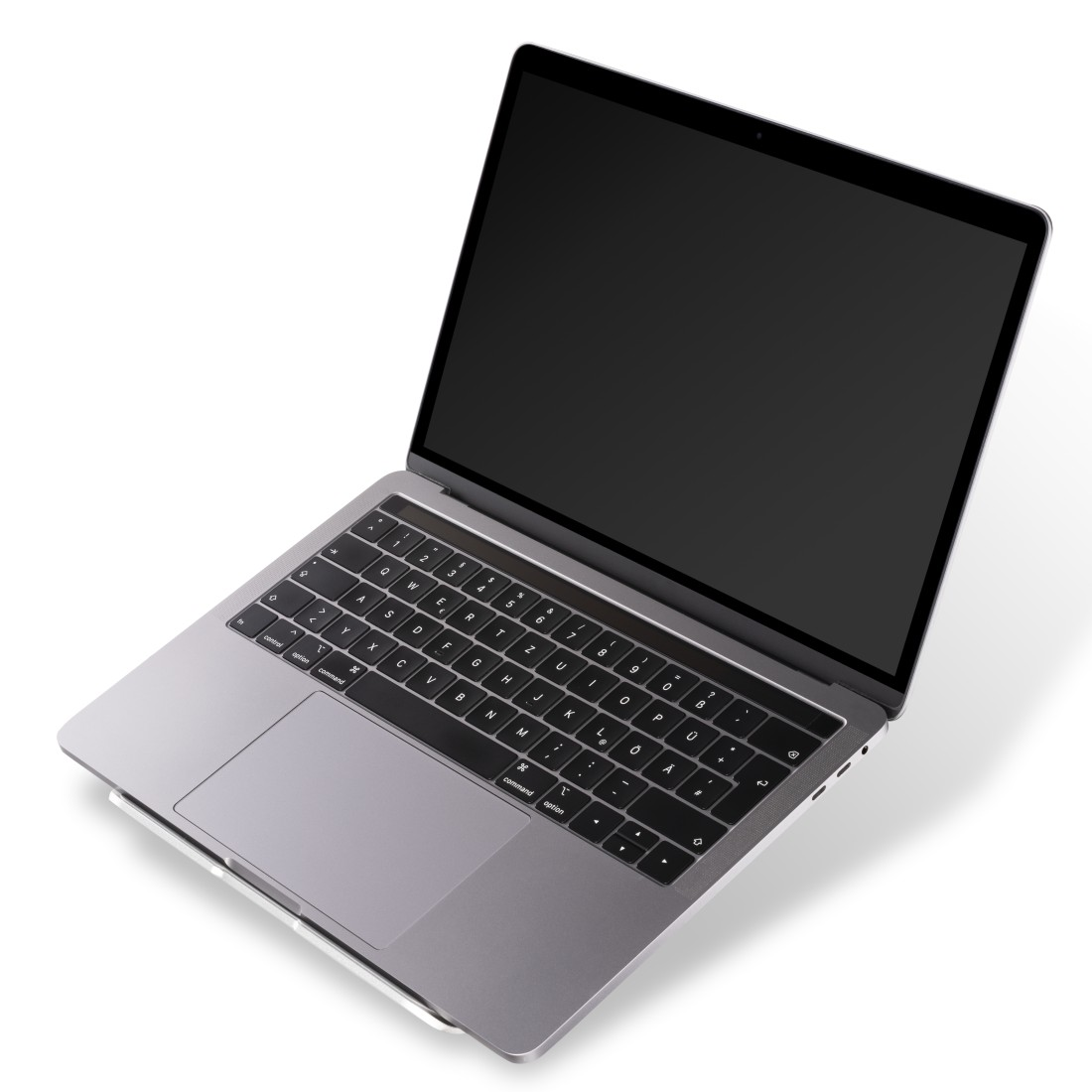 Una laptop con pantalla negra está abierta sobre una superficie blanca. El teclado es visible.