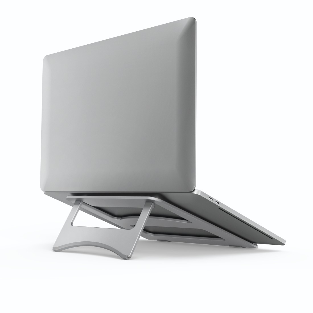 Una laptop plateada se eleva sobre un soporte plateado. Se ve la parte trasera de la laptop y el diseño del soporte.