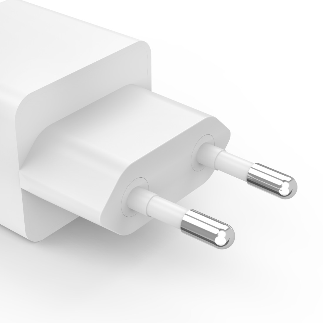 Adaptador de corriente blanco con dos clavijas con punta plateada. El adaptador está sobre un fondo blanco.