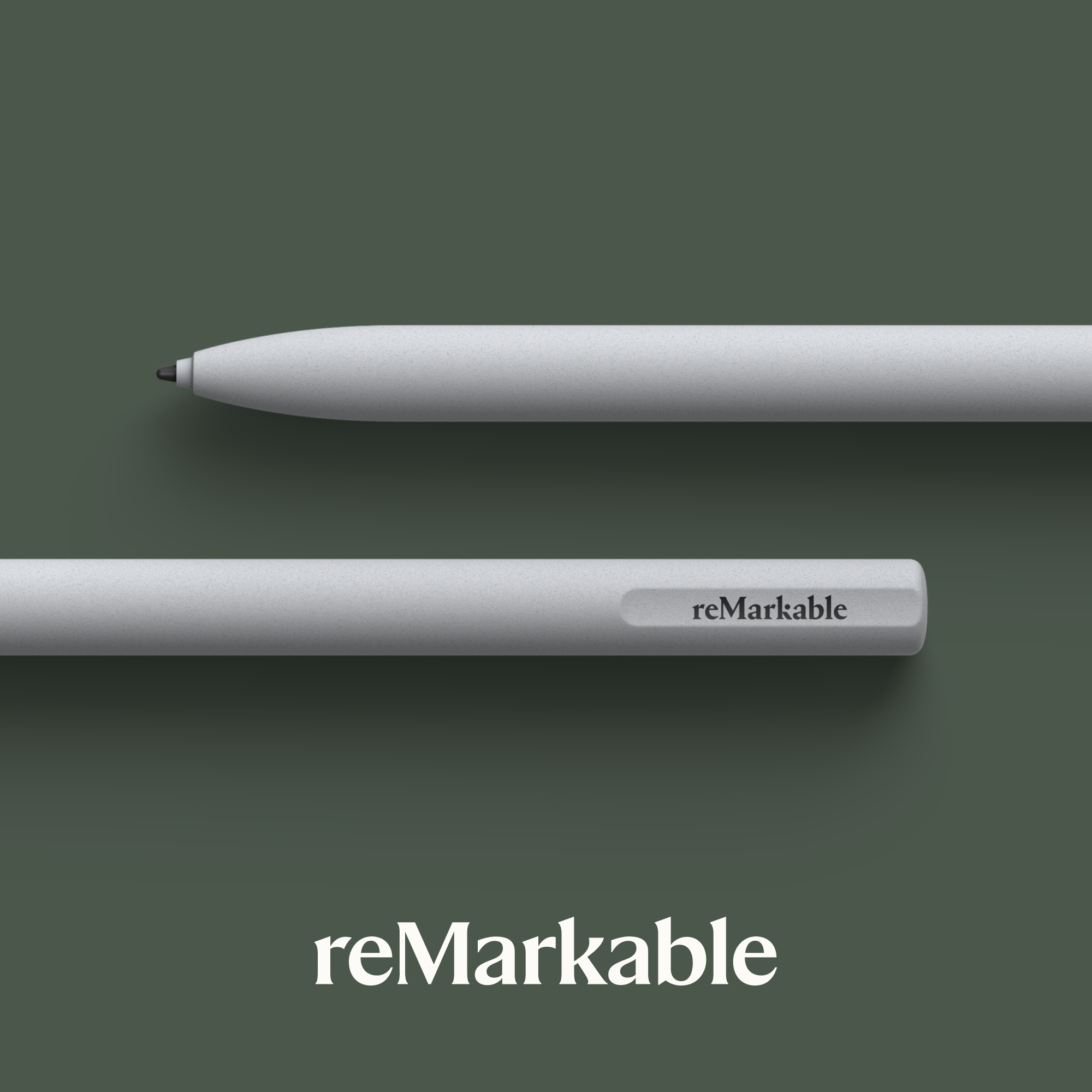 Zwei graue Stifte liegen auf einer dunkelgrünen Oberfläche, mit einem weißen "reMarkable"-Logo.