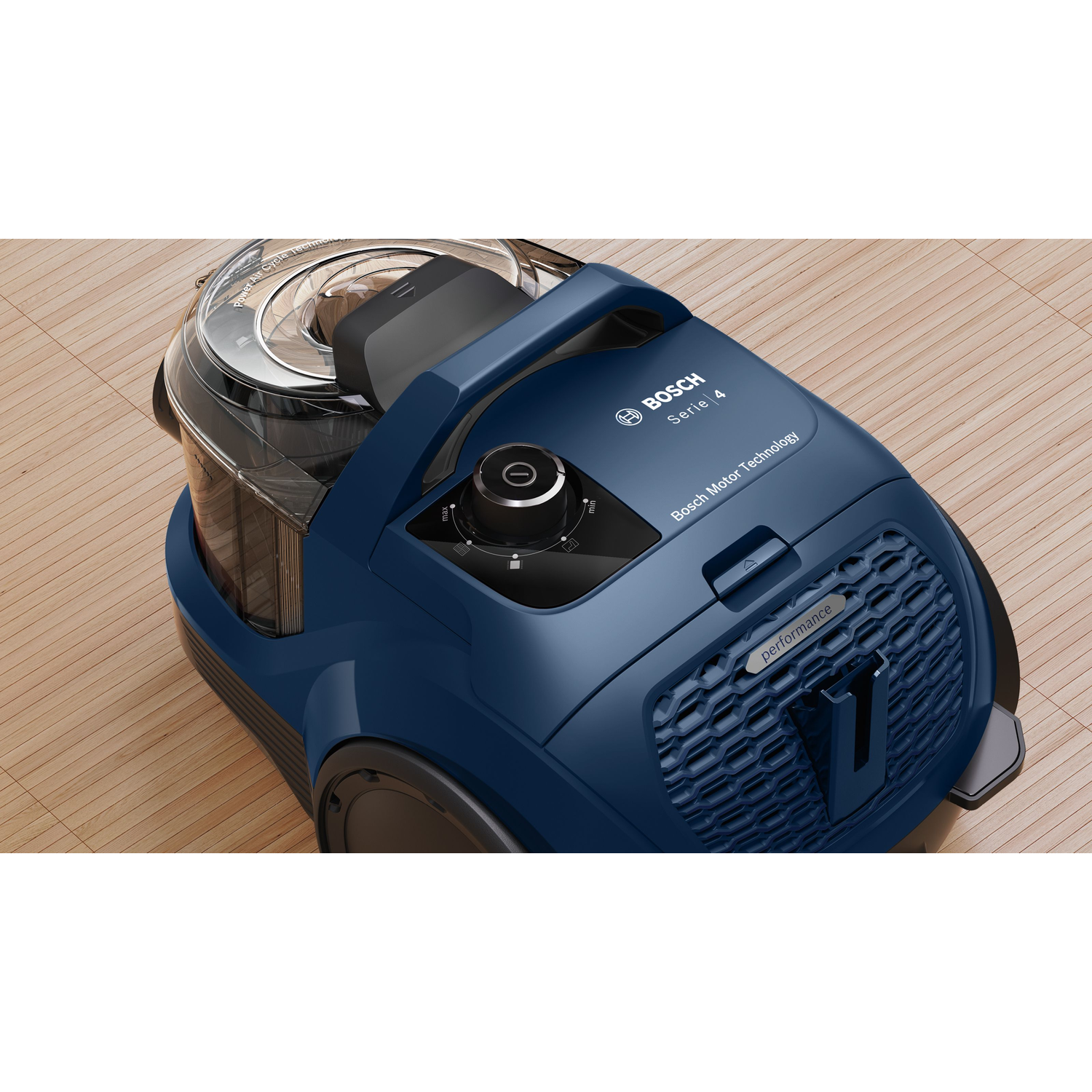 Dark blue vacuum cleaner on a wooden floor, with a black control dial and handle.