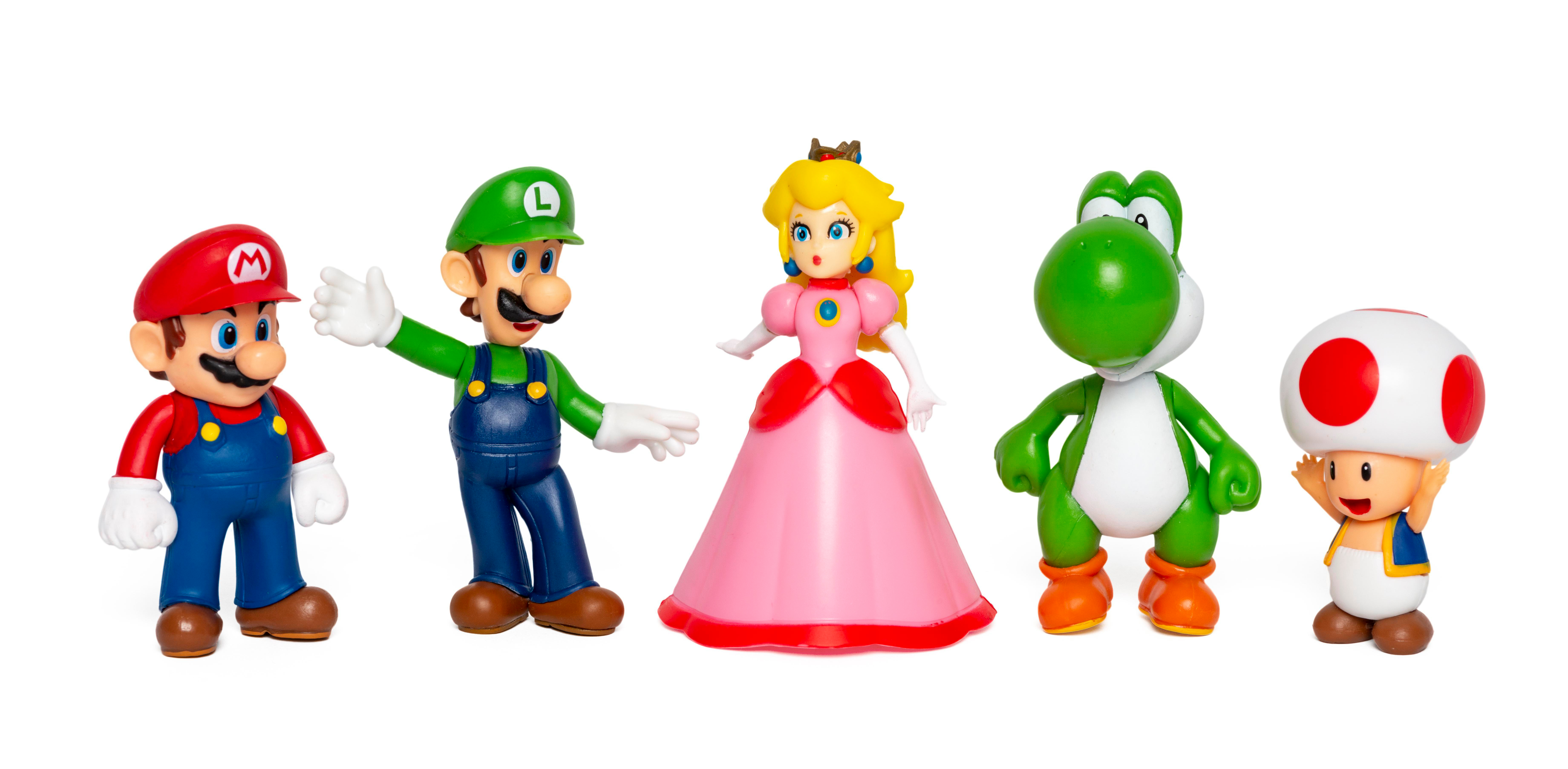 Gruppe von Mario-Charakterfiguren: Mario, Luigi, Peach, Yoshi und Toad. Weißer Hintergrund.