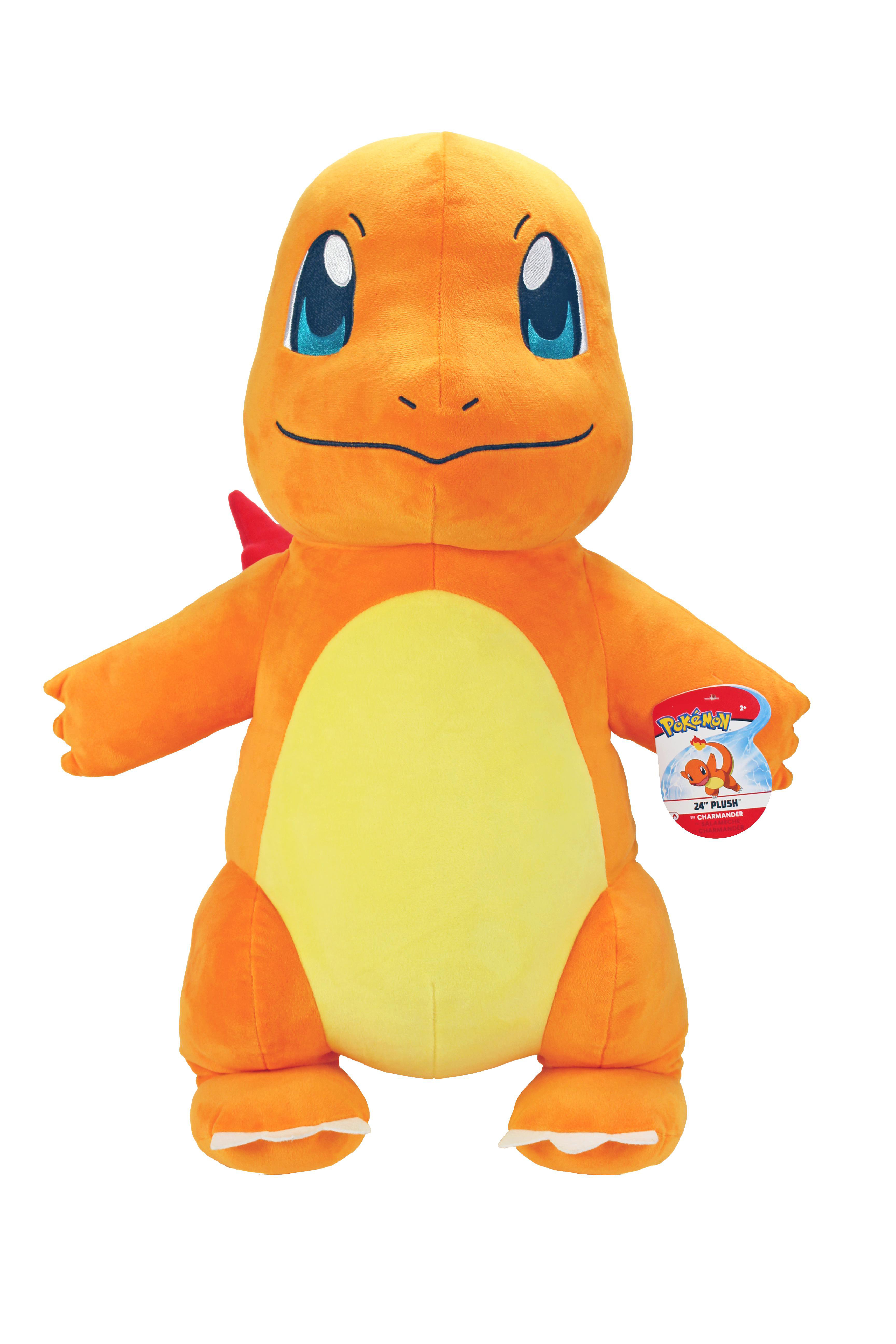 Ein orangefarbenes Charmander-Plüschtier mit blauen Augen und gelbem Bauch, roter Flosse und einem Etikett.
