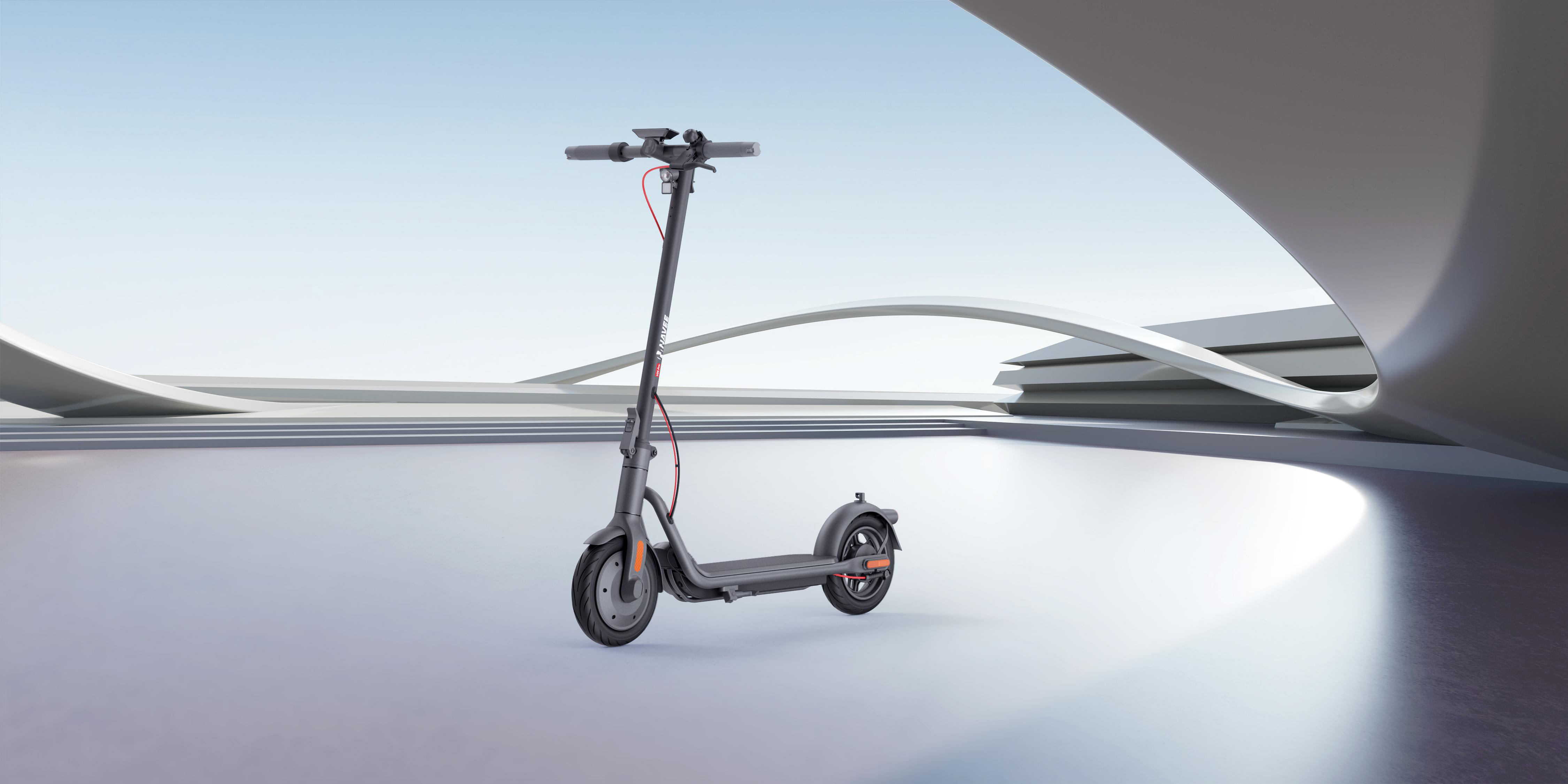 Ein schwarz-grauer Elektroroller auf einer glänzenden Oberfläche. Der Hintergrund ist ein verschwommenes, abstraktes Design.