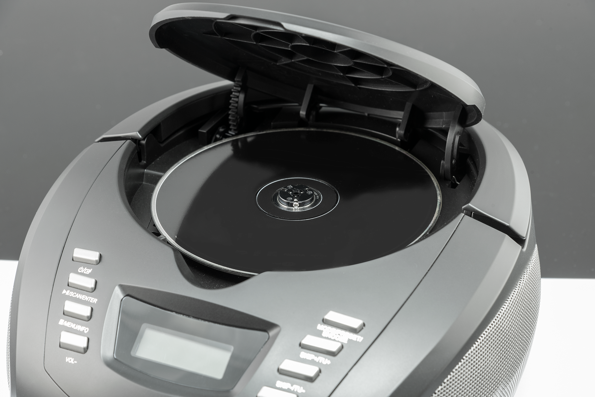 Czarny odtwarzacz CD z otwartą pokrywą i płytą CD w środku. Przyciski i wyświetlacz są widoczne.