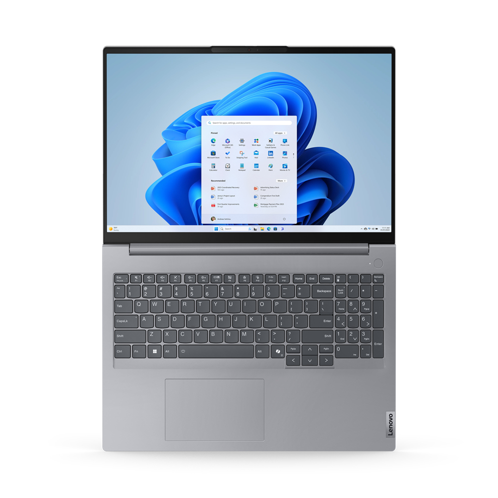 Un portátil plateado desde arriba, abierto, mostrando la interfaz de Windows 11. El fondo es un diseño floral azul.