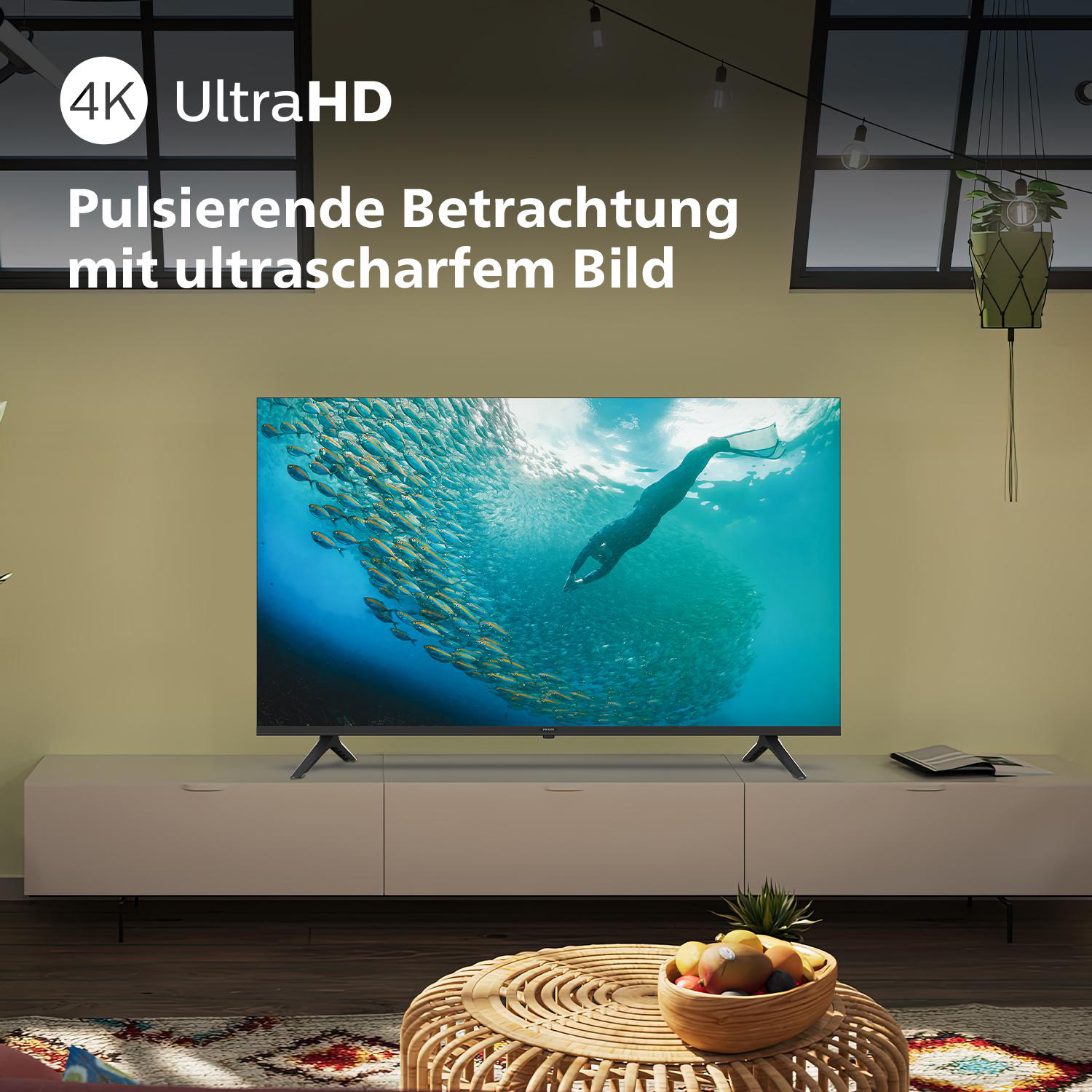 TV auf einem Ständer, der einen Taucher und Fische zeigt. Text: Pulsierende Betrachtung mit ultrascharfem Bild.
