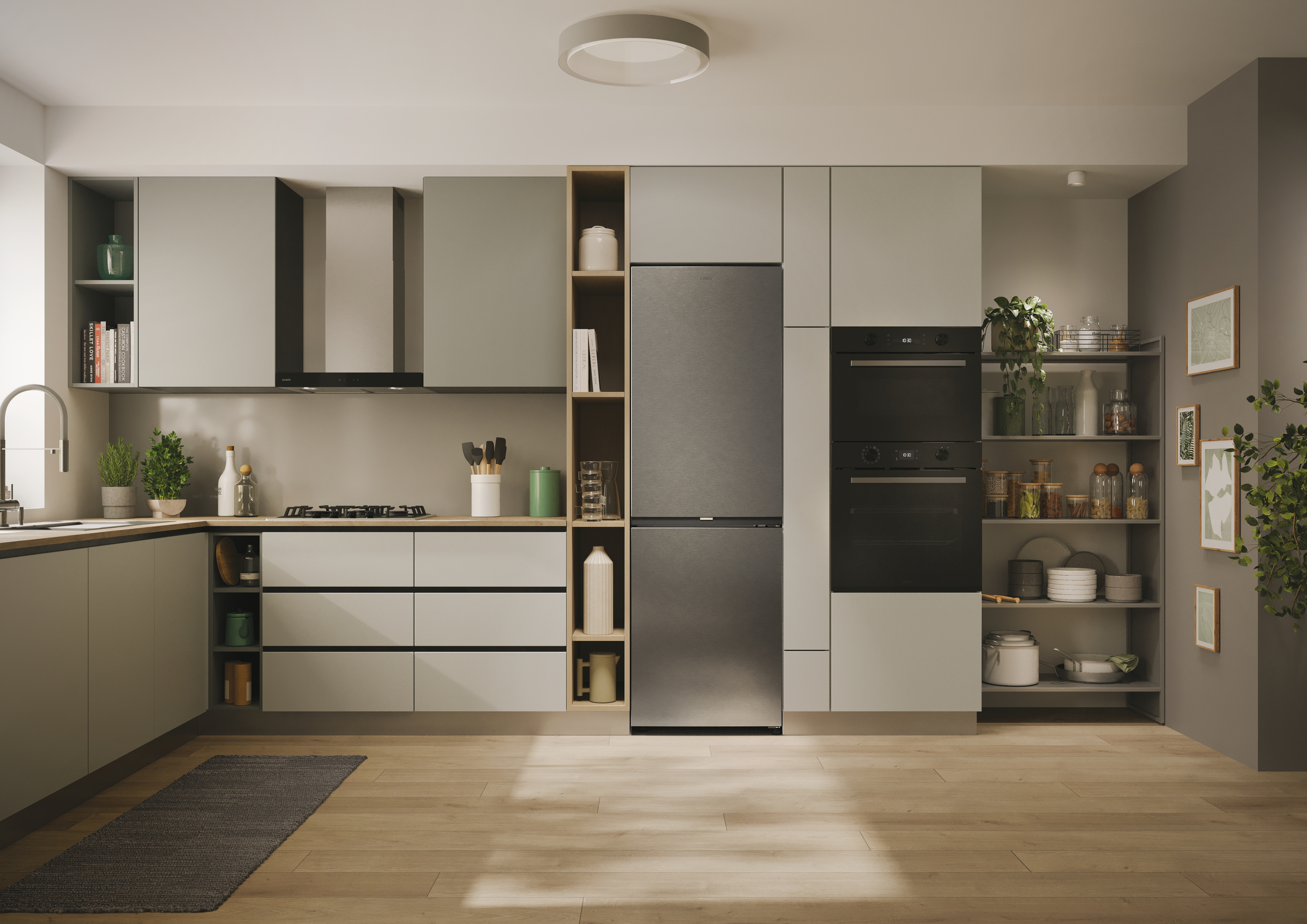 Cocina moderna con gabinetes grises, electrodomésticos de acero inoxidable y un refrigerador. Libros y plantas.